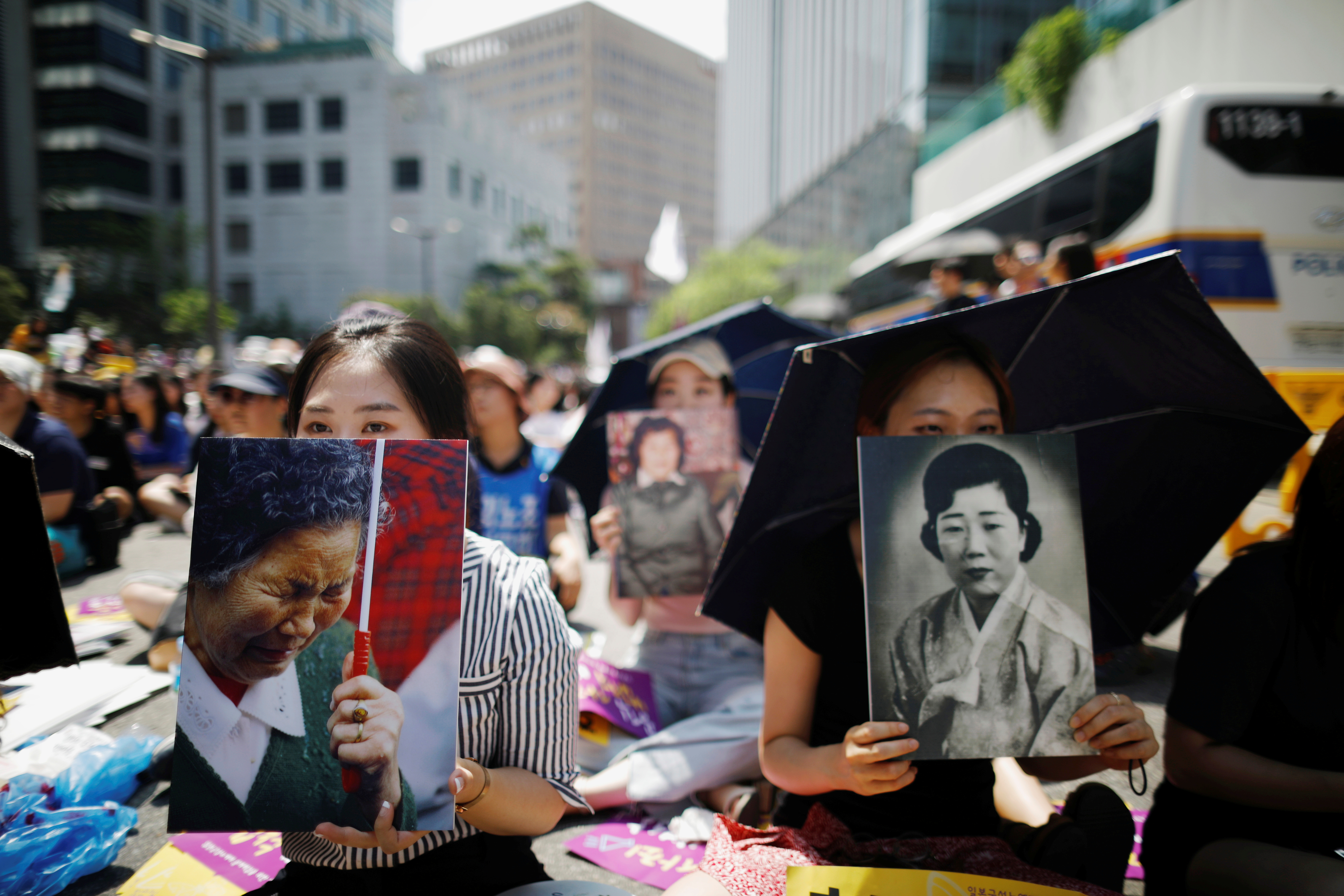 Women hold portraits of deceased former South Korean &#039;comfort women&#039; during a weekly anti-Japan rally in Seoul, South Korea, August 15, 2018 [Kim Hong-Ji/Reuters]