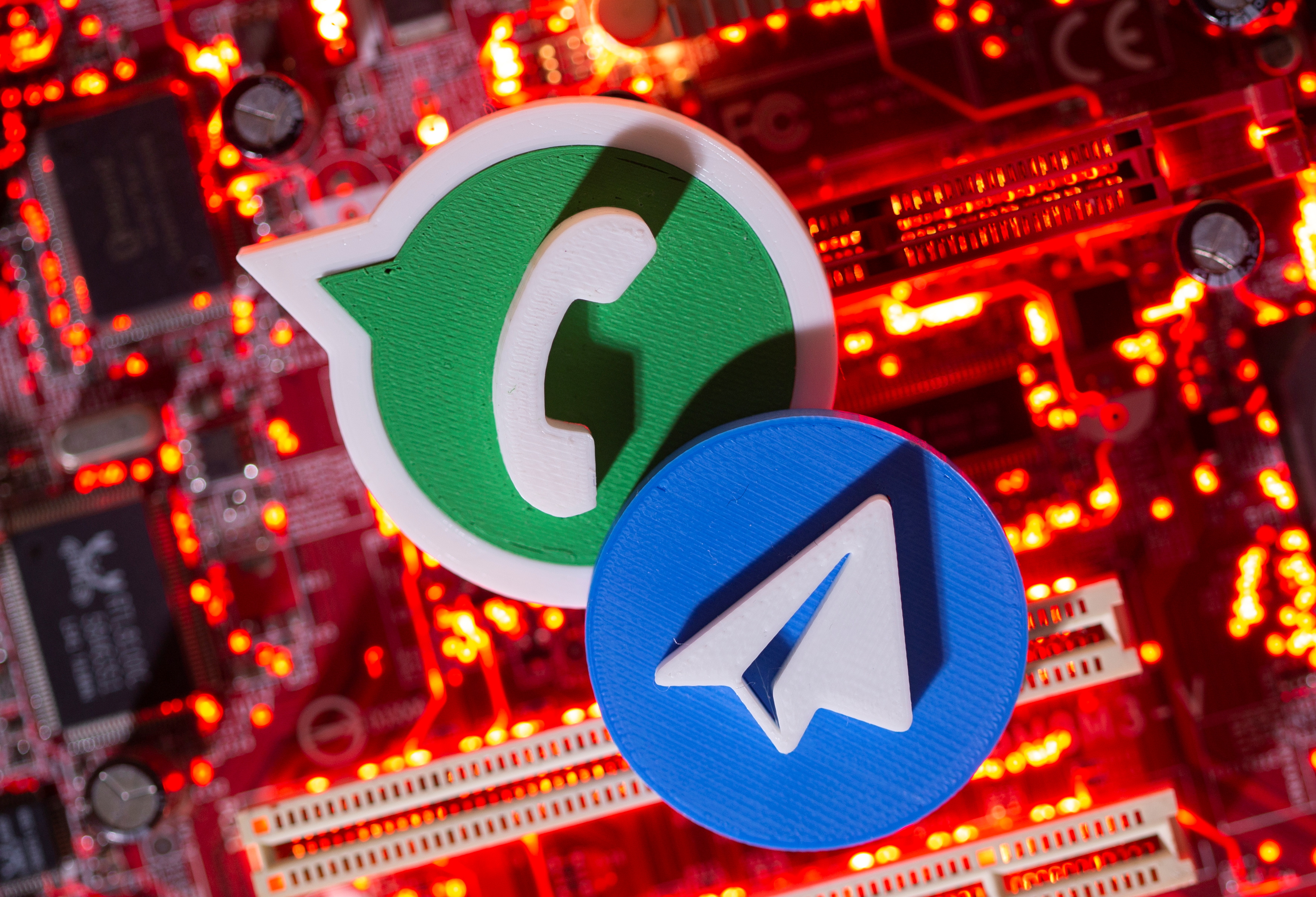 3D printed Telegram and WhatsApp logos are placed on a computer motherboard in this illustration taken January 21, 2021. REUTERS/Dado Ruvic/Illustration