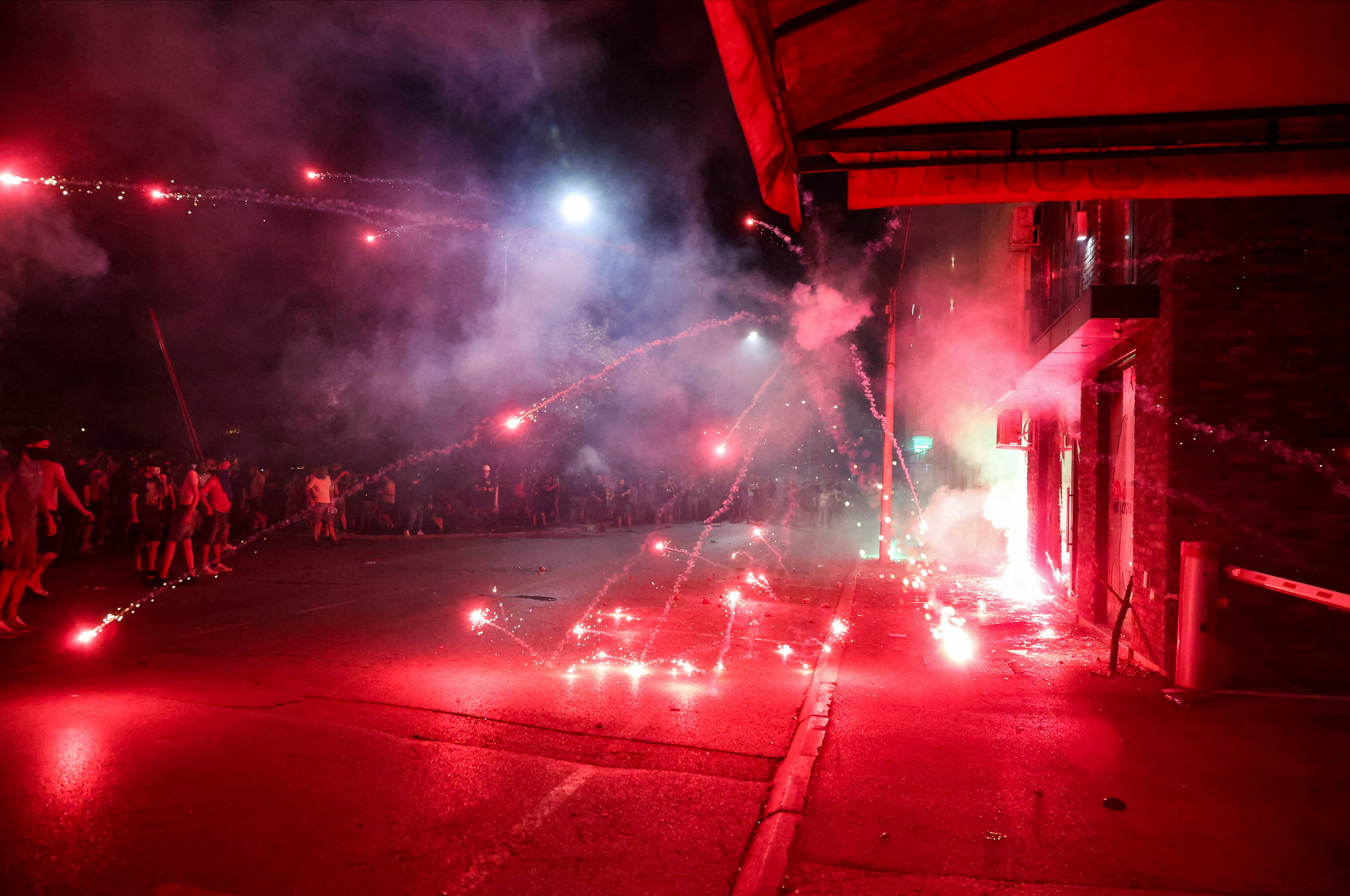 Antigovernment protesters throw fireworks.