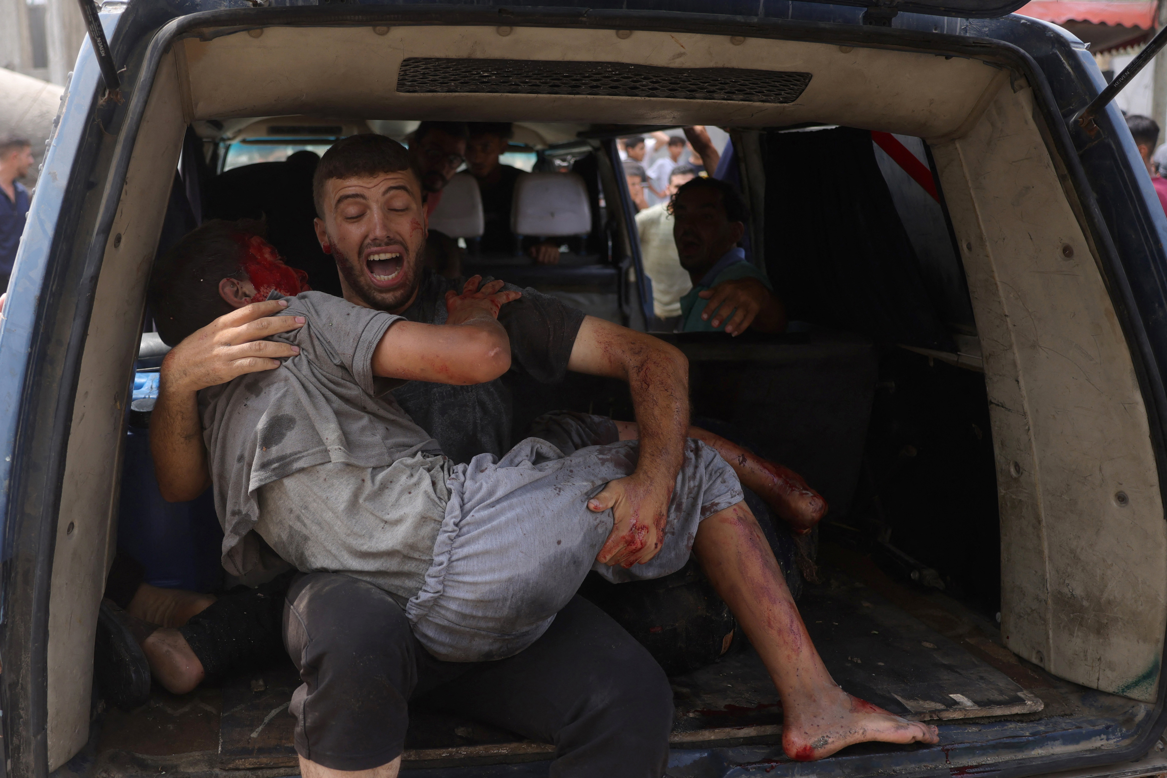 EDITORS NOTE: Graphic content / A Palestinian man carries a wounded youth, evacuated from the site of an Israeli strike, west of Gaza City on August 12, 2025.