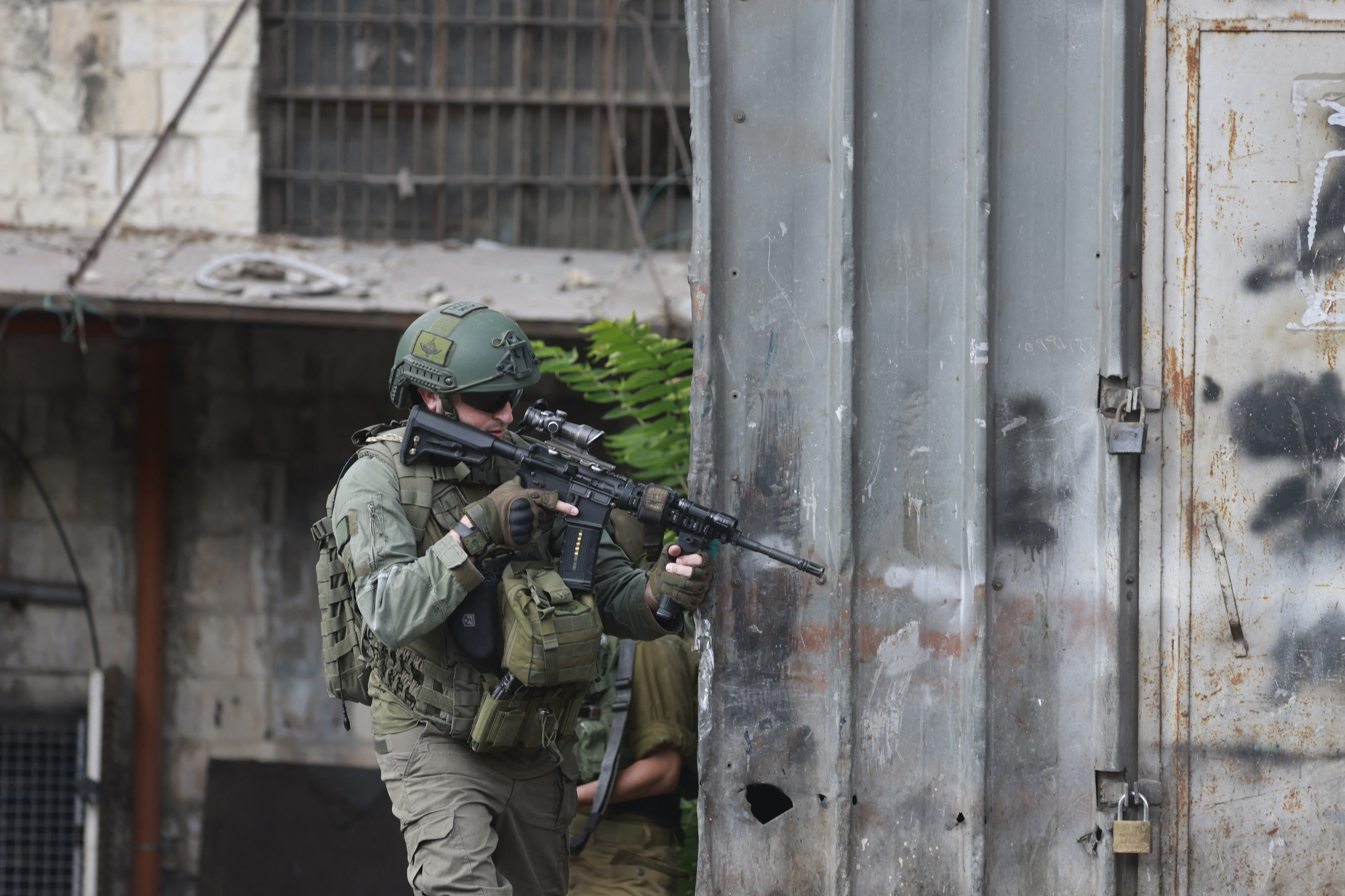 Israeli troops take position during a raid in Nablus city in the occupied West Bank on August 27, 2025. (Photo by Jaafar ASHTIYEH / AFP)