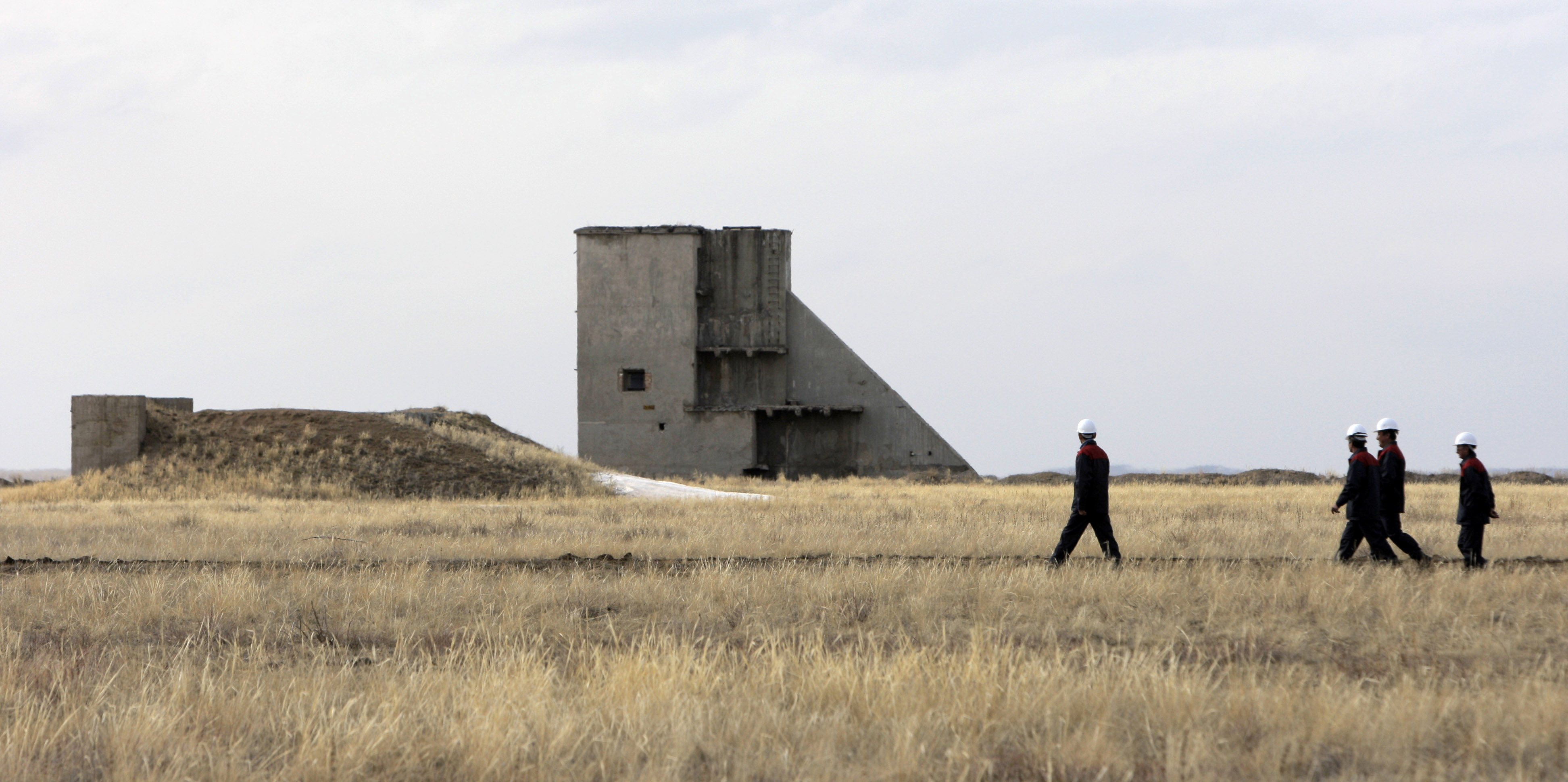 Workers pass a structure at the former Semipalatinsk nuclear bomb testing centre.