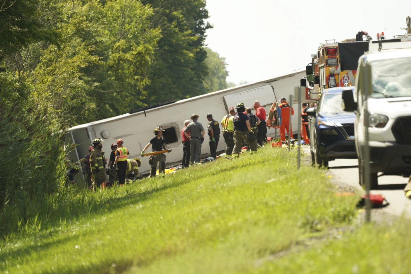First responders work to rescue victims at the scene of a tour bus that crashed and rolled over on the New York State Thruway near Pembroke, N.Y., Friday, Aug. 22, 2025. (Libby March/Buffalo News via AP)
