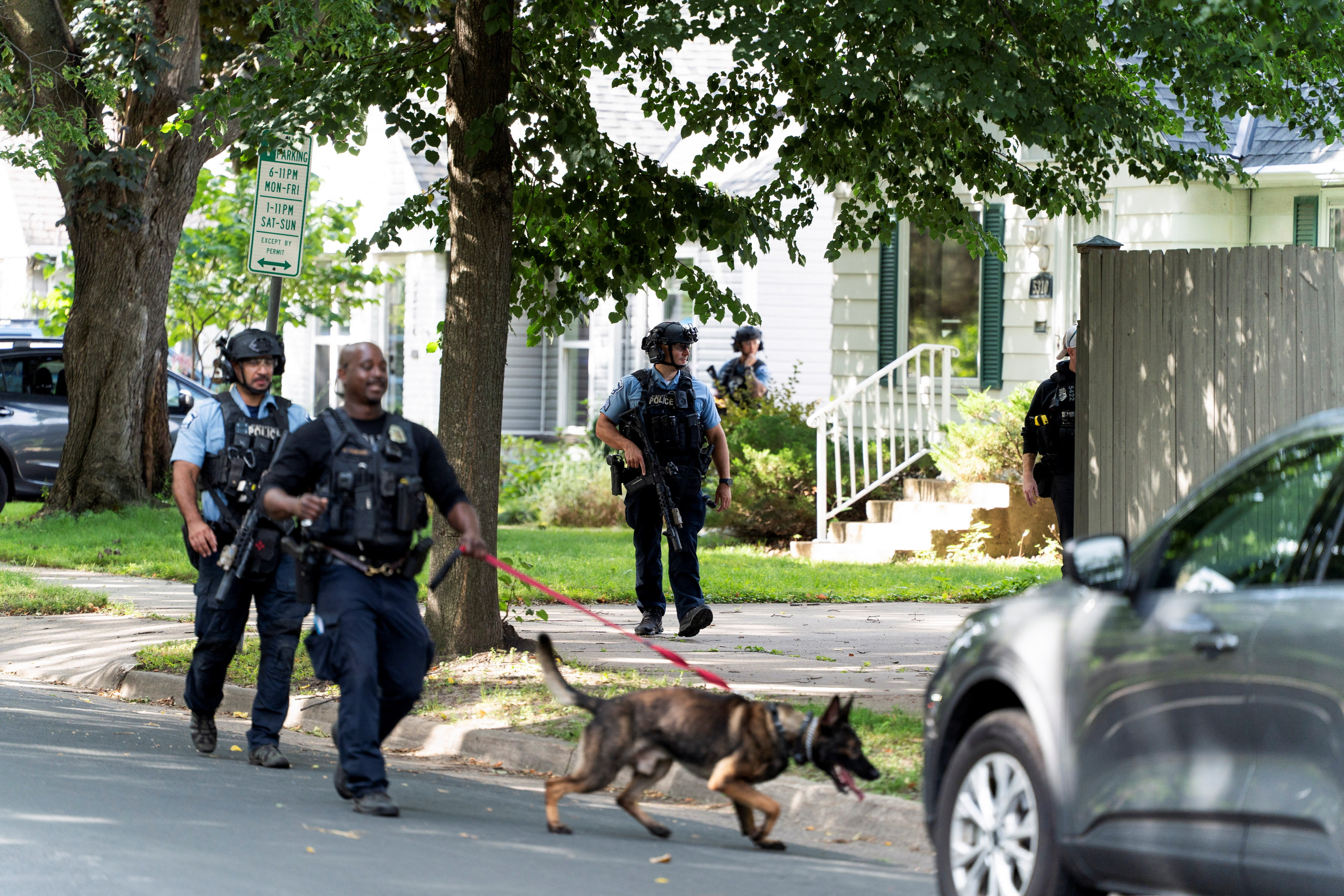 Law enforcement use a dog to search a neighborhood after a shooting at Annunciation Church, which is also home to an elementary school, in Minneapolis, Minnesota, US