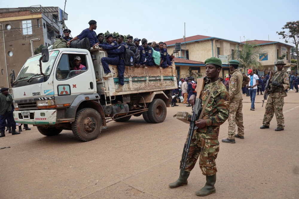 Members of the Congolese National Police climb into a truck after surrendering to the M23 armed group.