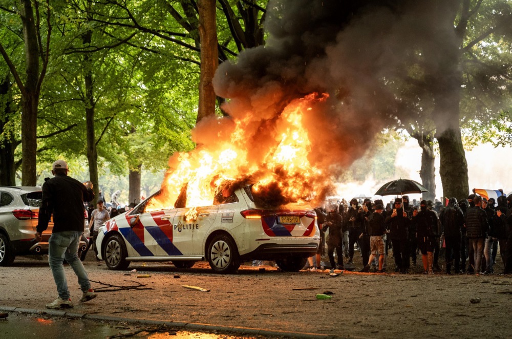 A police car is set on fire during a protest against the current asylum policy on the Malieveld, in the Hague, the Netherlands