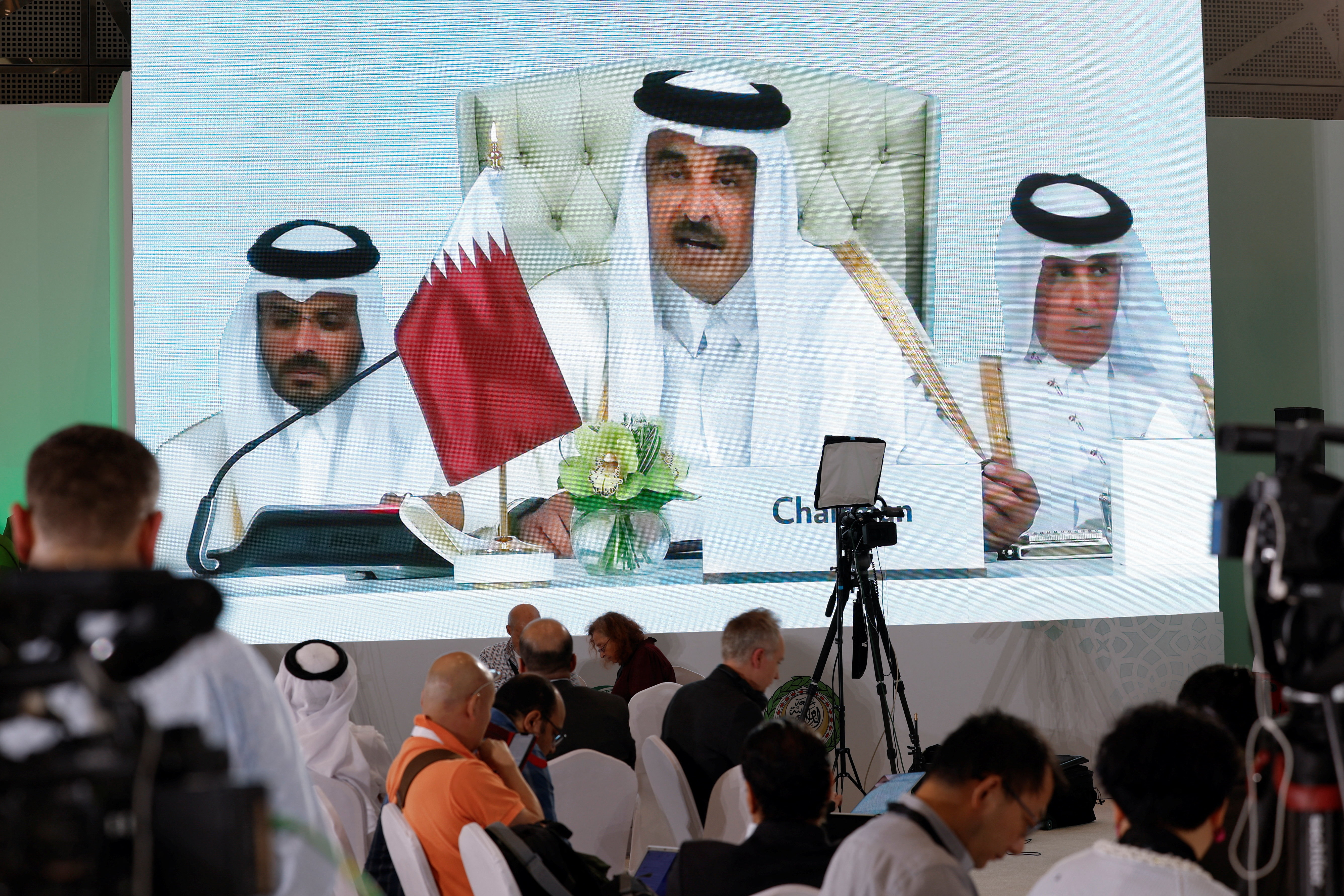 Journalists watch on a screen at the media center as Sheikh Tamim bin Hamad Al Thani, the emir of Qatar