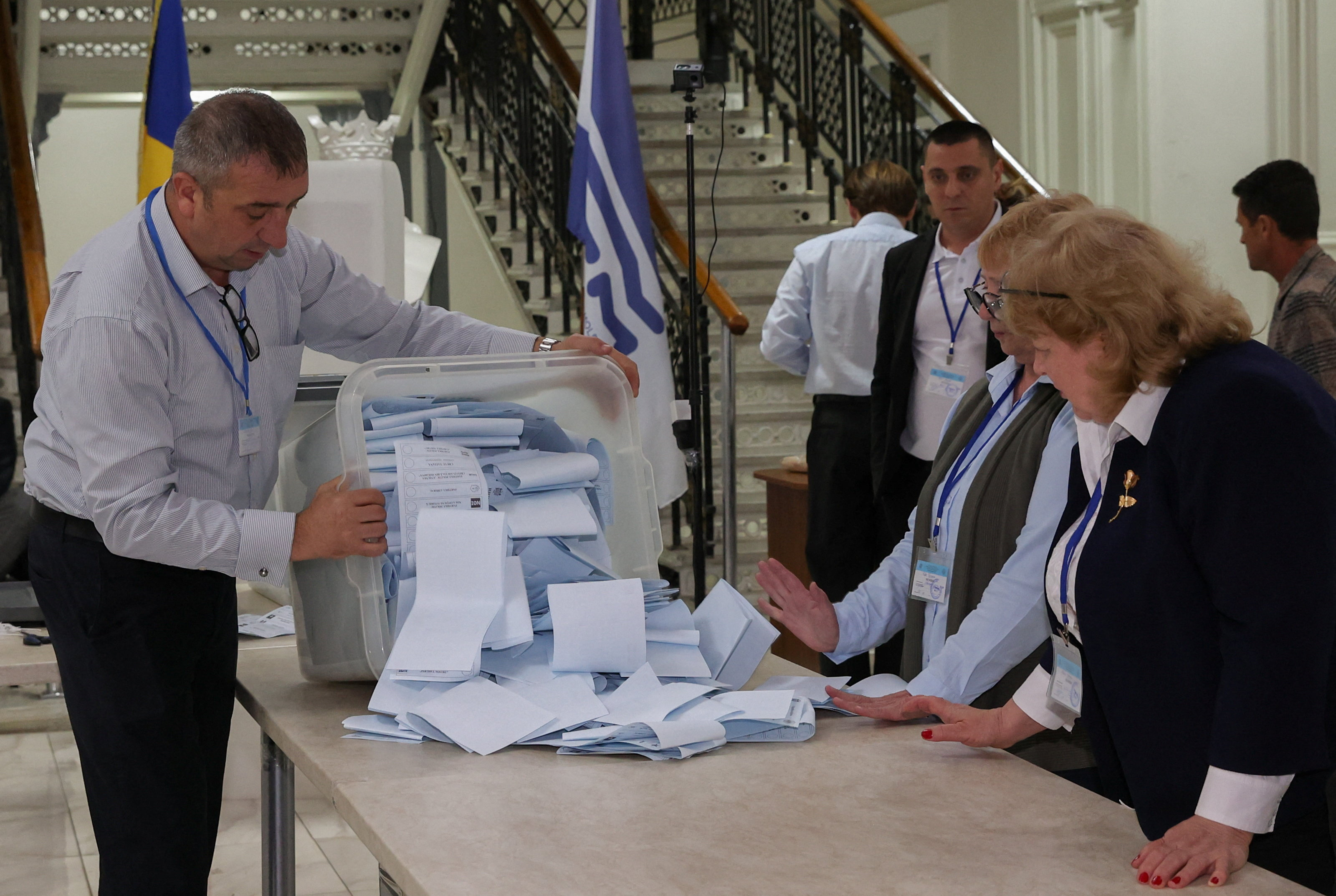 Members of an electoral commission empty a ballot box after polling stations closed in Moldova's parliamentary elections in Chisinau, Moldova