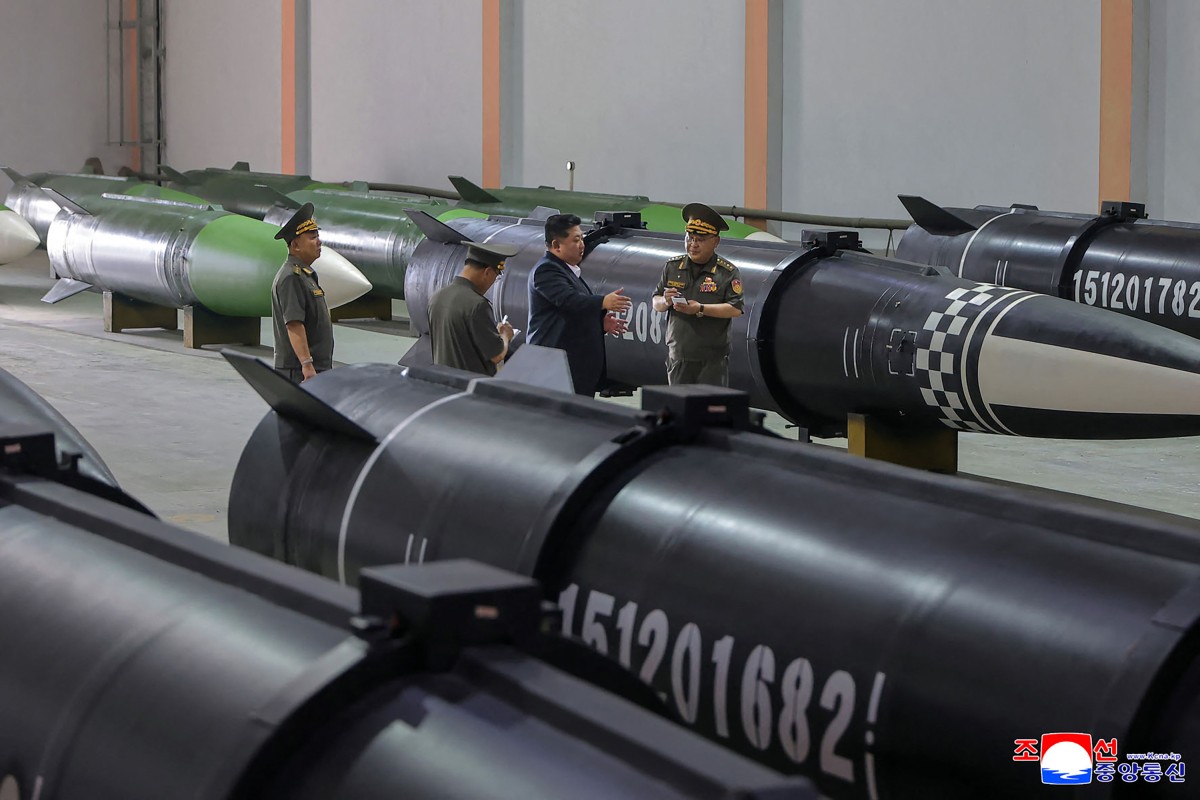 North Korean leader Kim Jong Un (2nd R) inspects the missile production process at a military manufacturing facility.