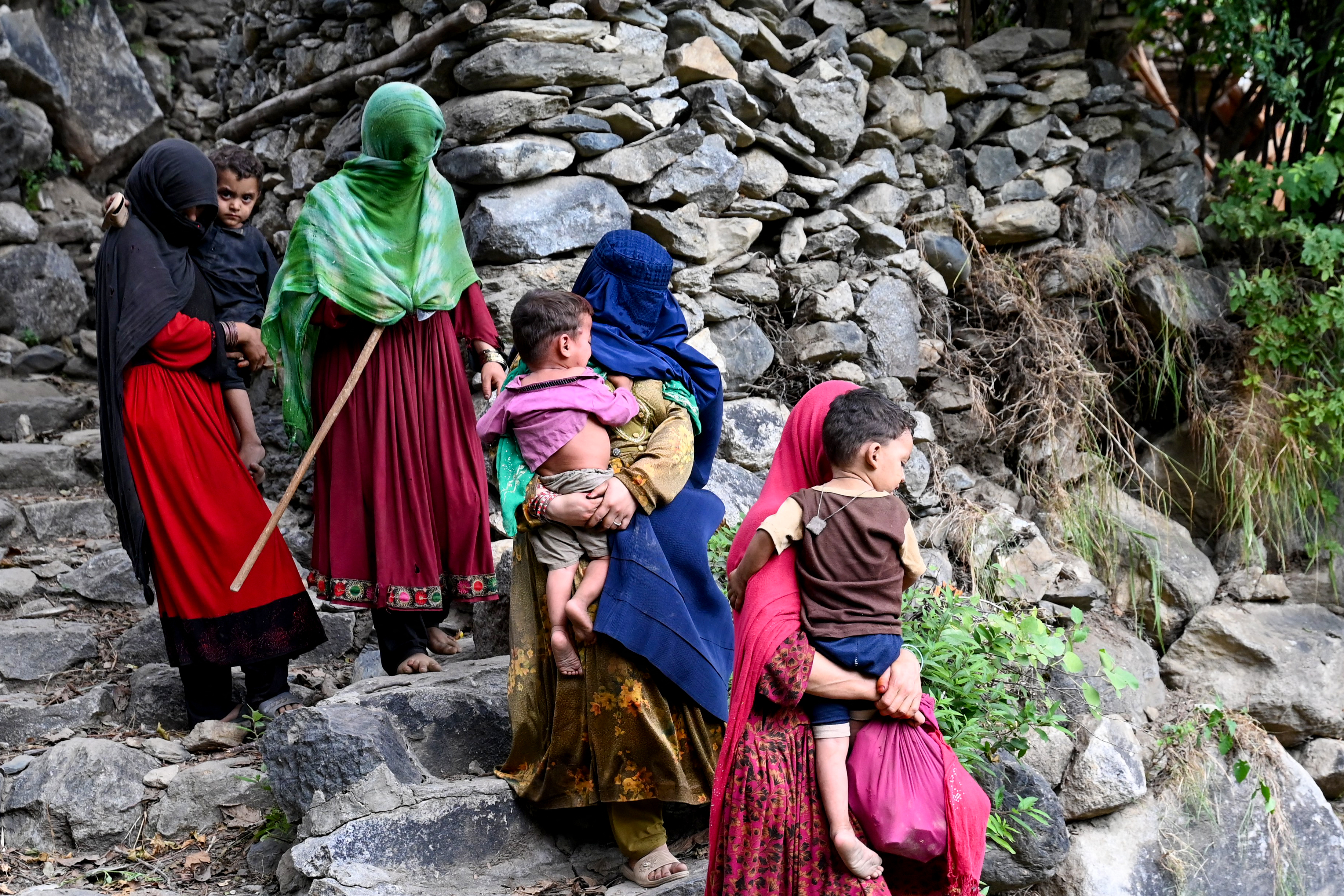 Afghan women and their children are pictured after earthquakes.