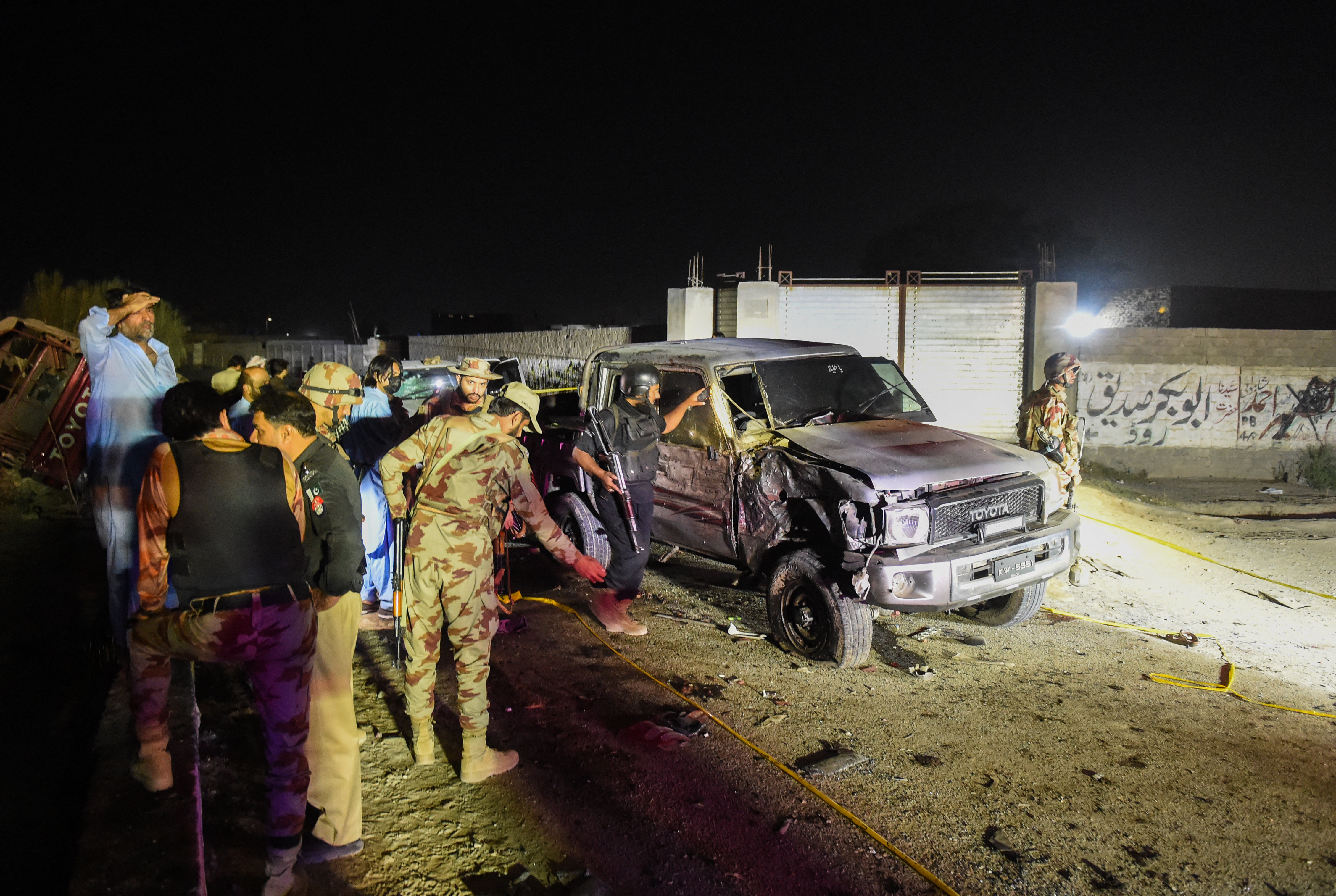 Security personnel inspect a damaged vehicle at the site of an explosion after a suicide bombing in Quetta on Setember 2, 2025.