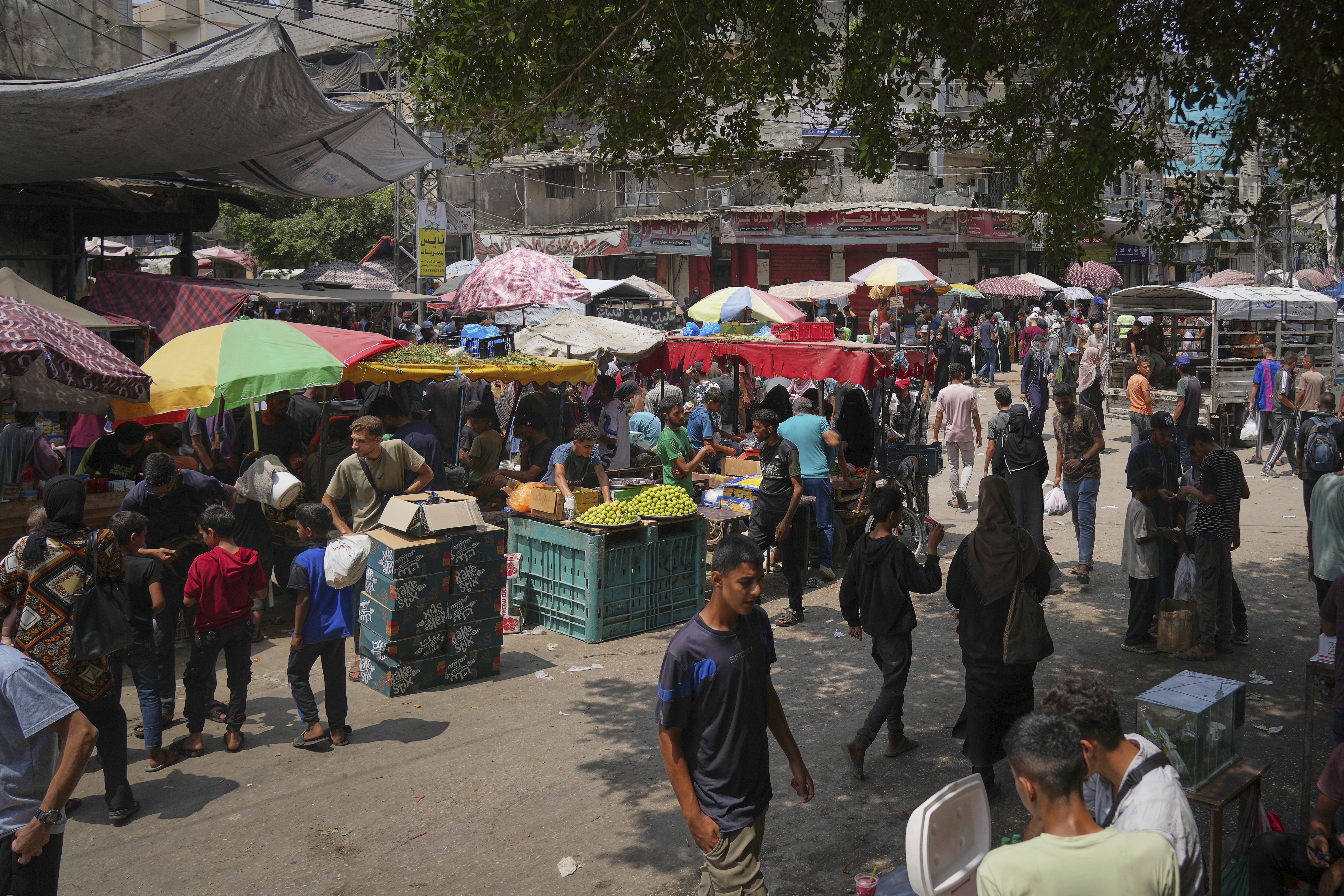 Palestinians shop at a makeshift market in Deir al-Balah, central Gaza Strip, Monday, Aug. 11, 2025. (AP Photo/Abdel Kareem Hana)