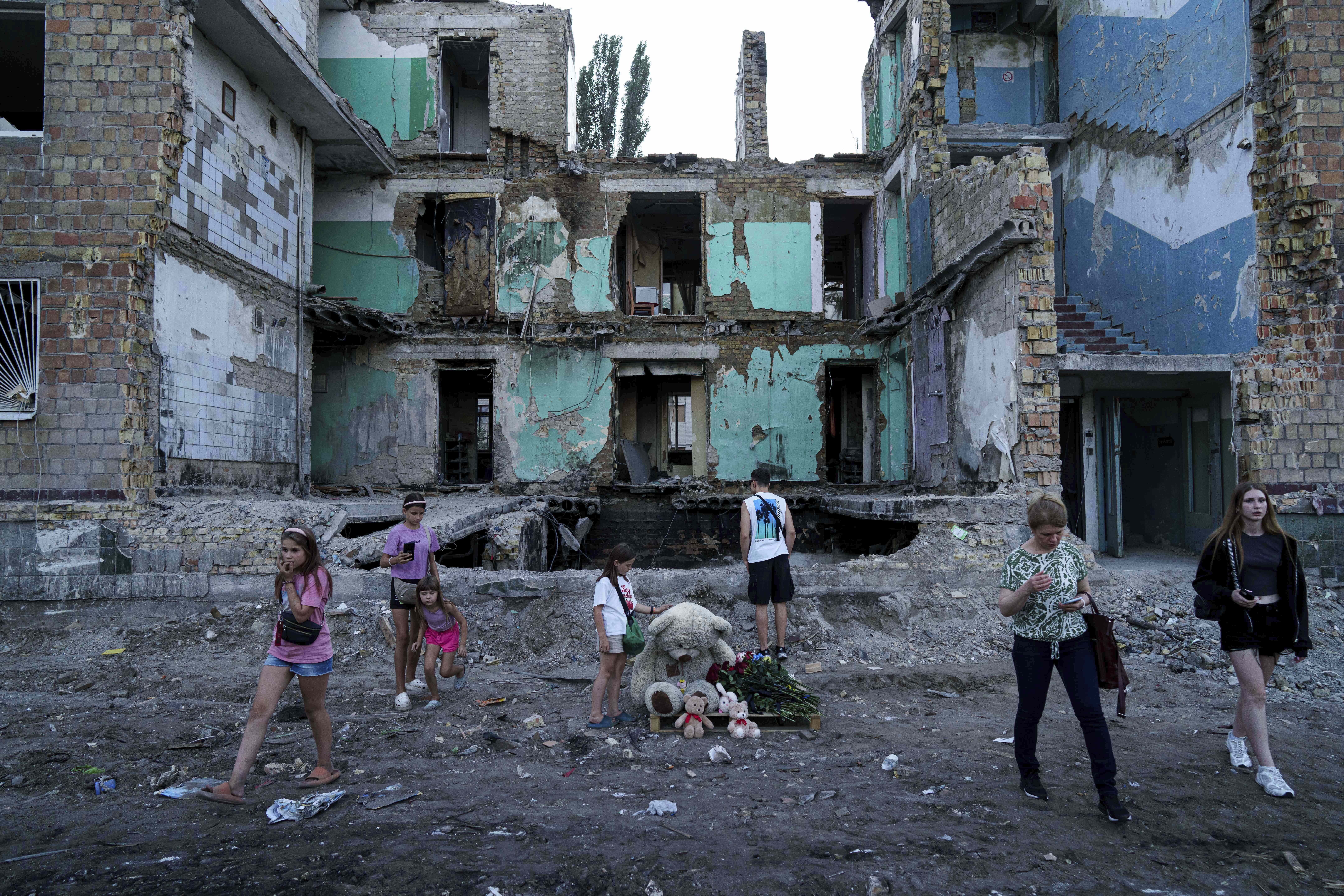 People look at a house destroyed by a Russian strike in Kyiv, Ukraine, on Friday, Aug. 29, 2025. (AP Photo/Evgeniy Maloletka)