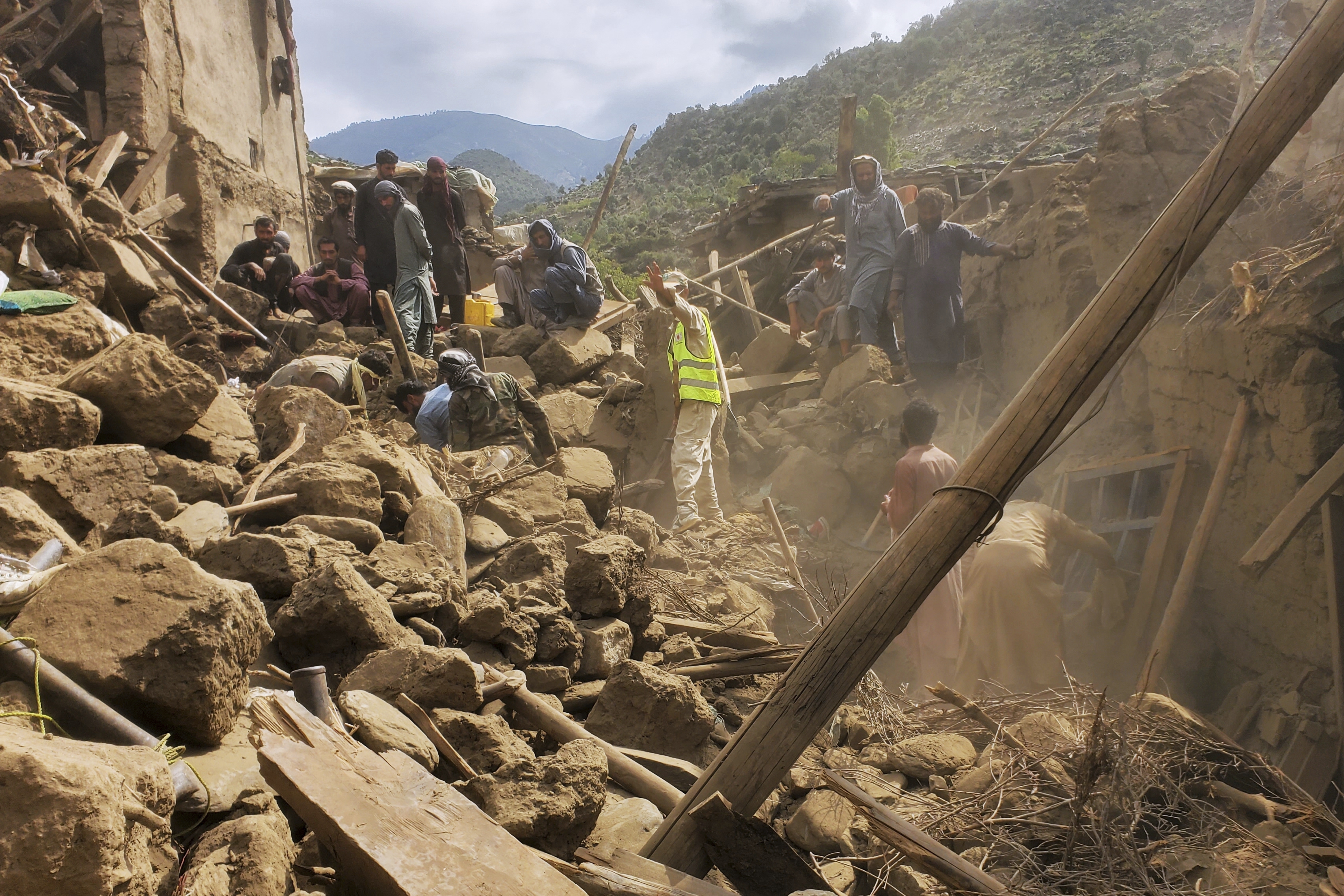 Civil defence workers, locals and army soldiers clear rubble as they search for survivors in Mazar Dara, Kunar province, Afghanistan