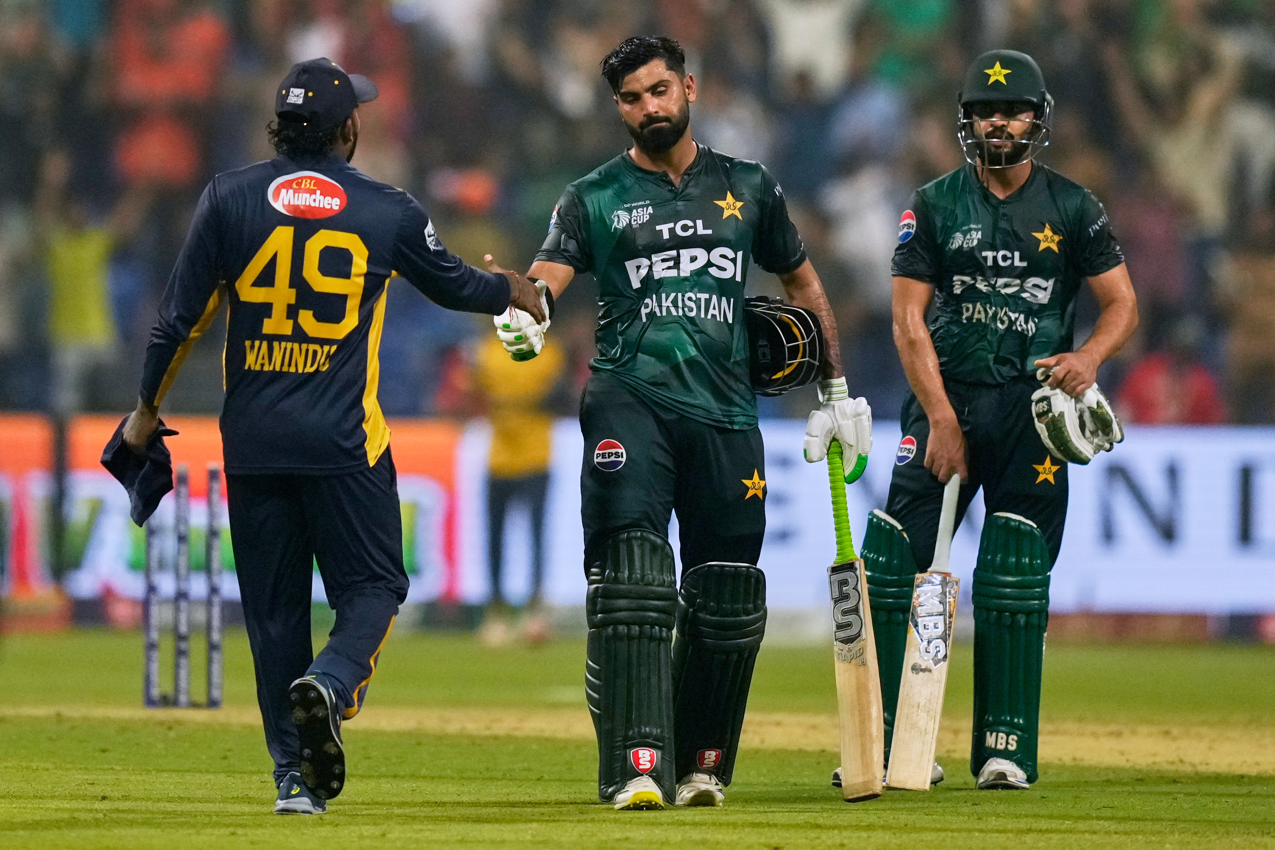 Pakistan's Hussain Talat shakes hands with Sri Lanka's Wanindu Hasaranga after winning the Asia Cup cricket match between Pakistan and Sri Lanka at Zayed Cricket Stadium in Abu Dhabi, United Arab Emirates, Tuesday, Sept. 23, 2025. (AP Photo/Altaf Qadri)