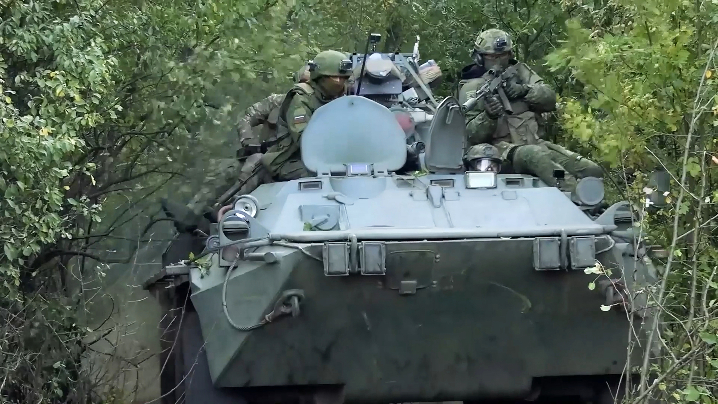 Russian soldiers ride an APC in an undisclosed location in Ukraine.