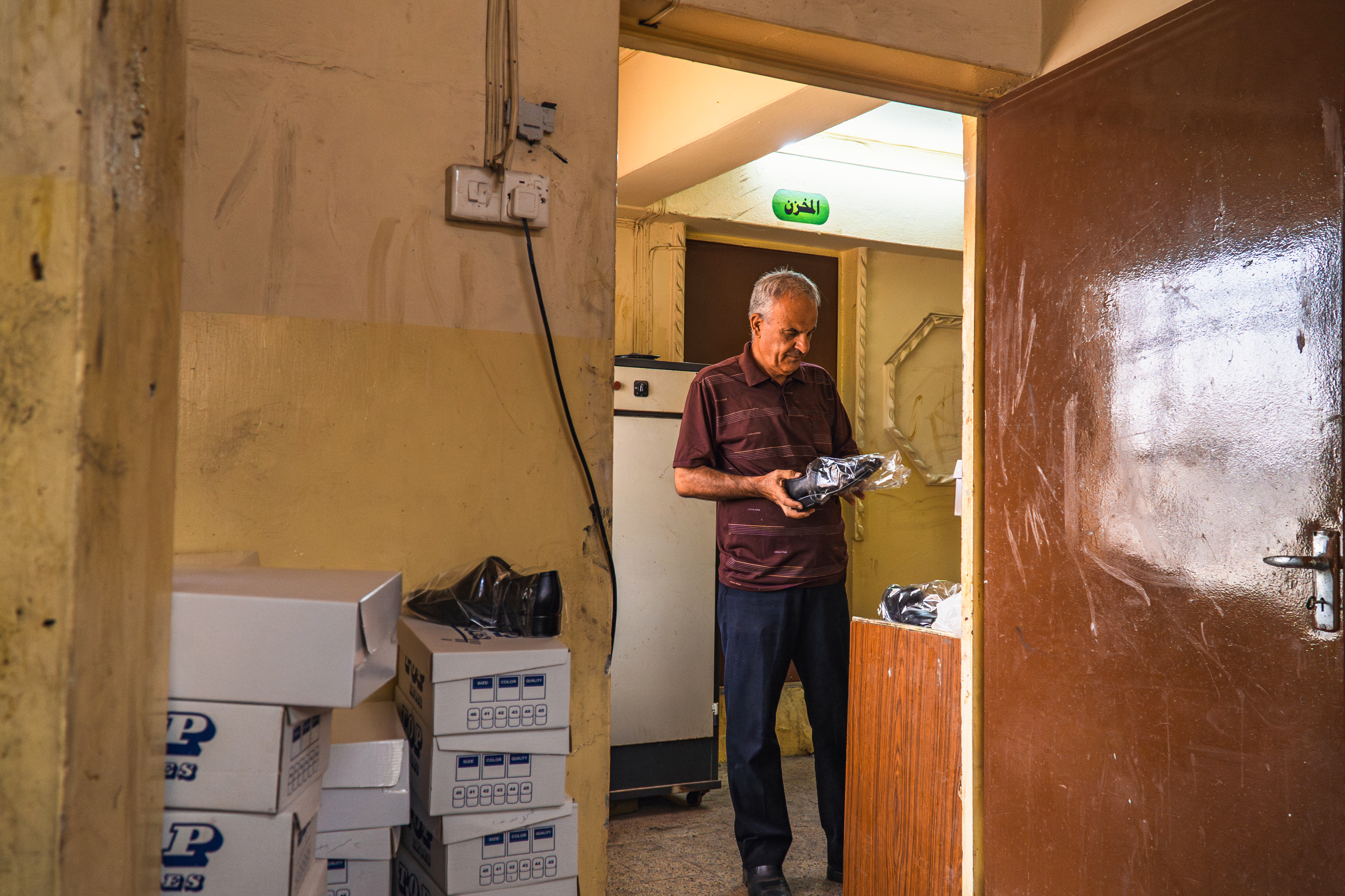 Saad performs a final quality check on a leather shoe before it reaches the market. Photo: IOM 2025/Aram Hakim