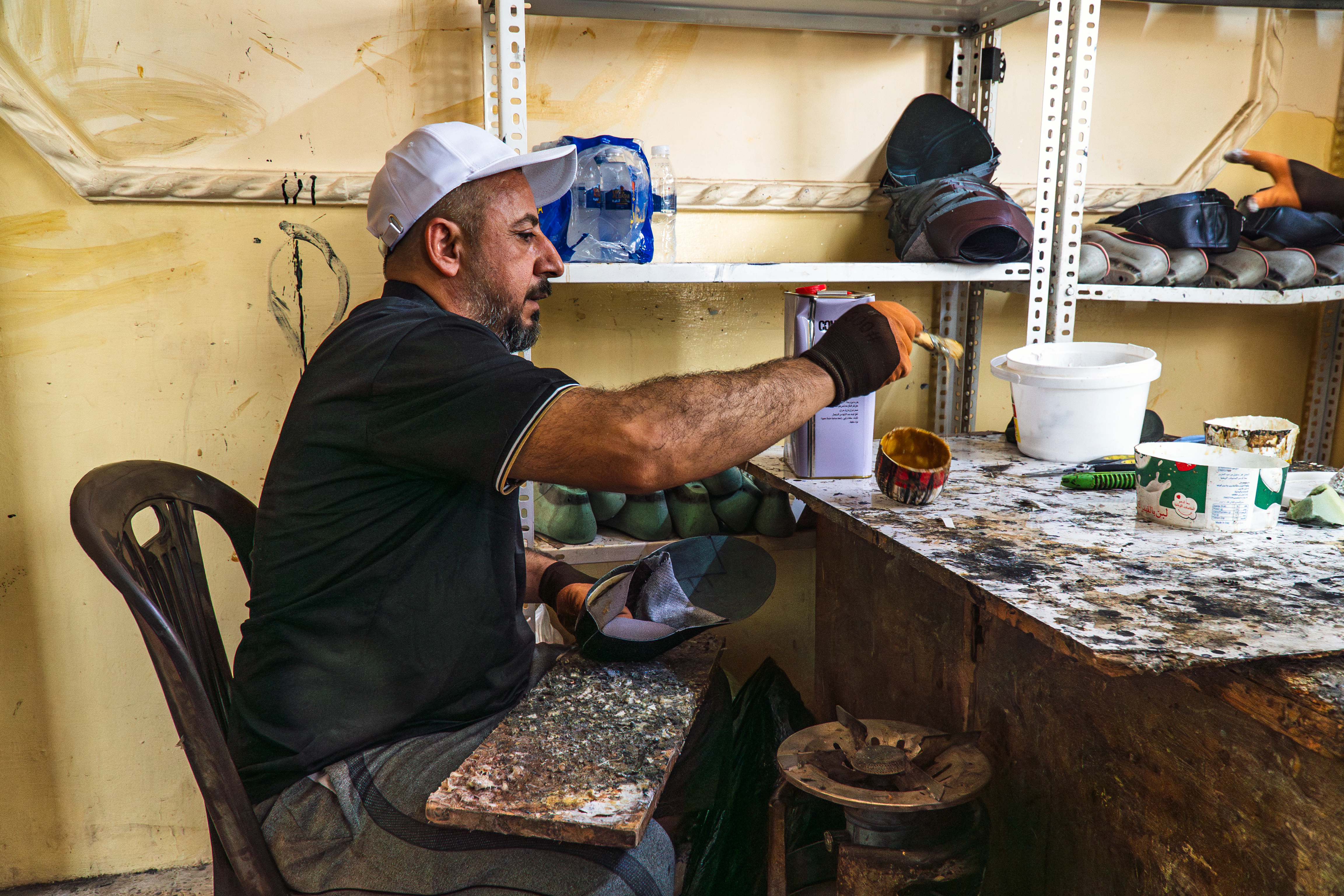In Mosul, artisans cut and glue leather by hand before stitching shoes together. Photo: IOM 2025/Aram Hakim