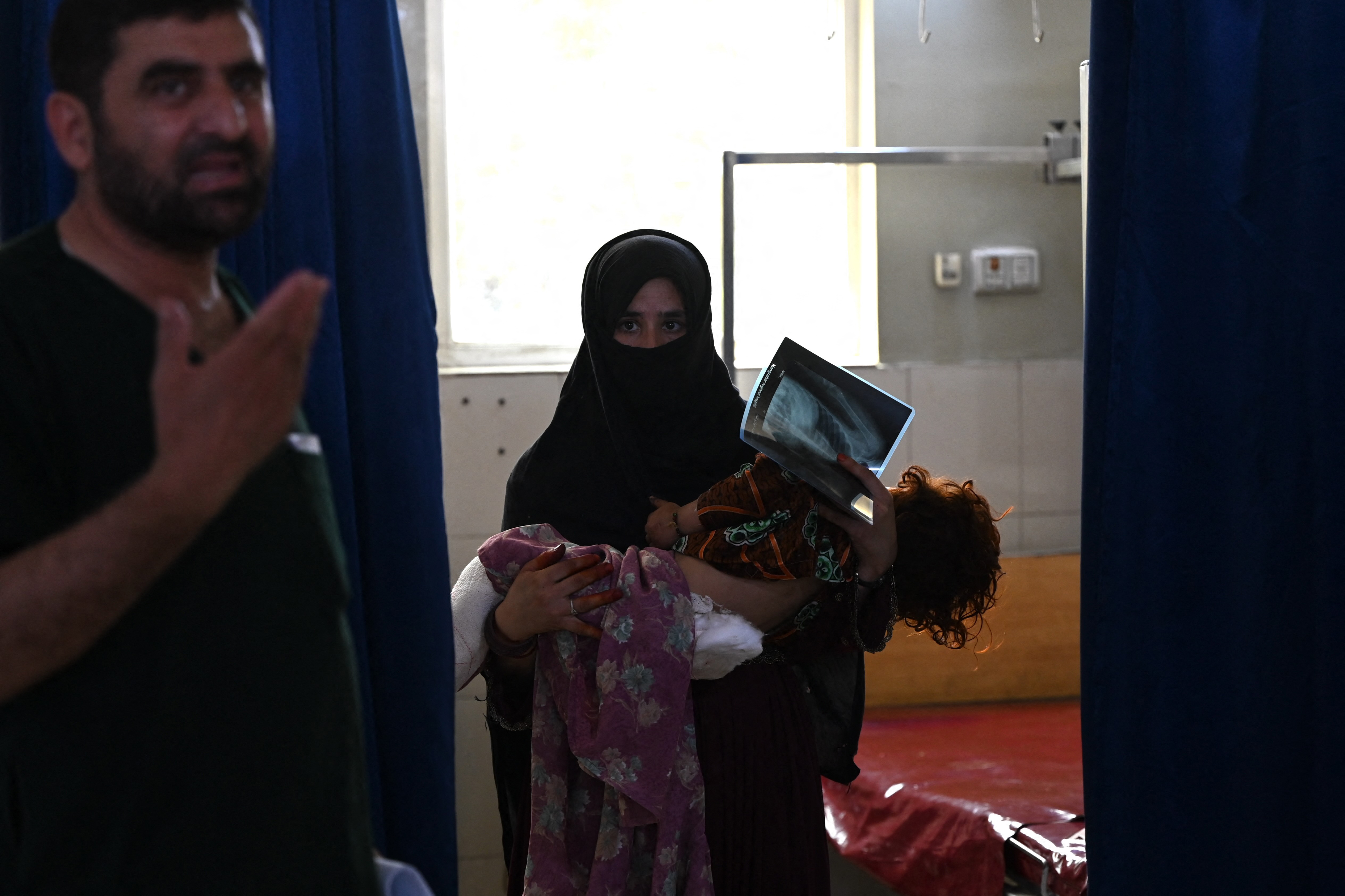 EDITORS NOTE: Graphic content / An Afghan woman carries her daughter after being injured during earthquakes, for treatment at a hospital in Jalalabad on September 2, 2025.