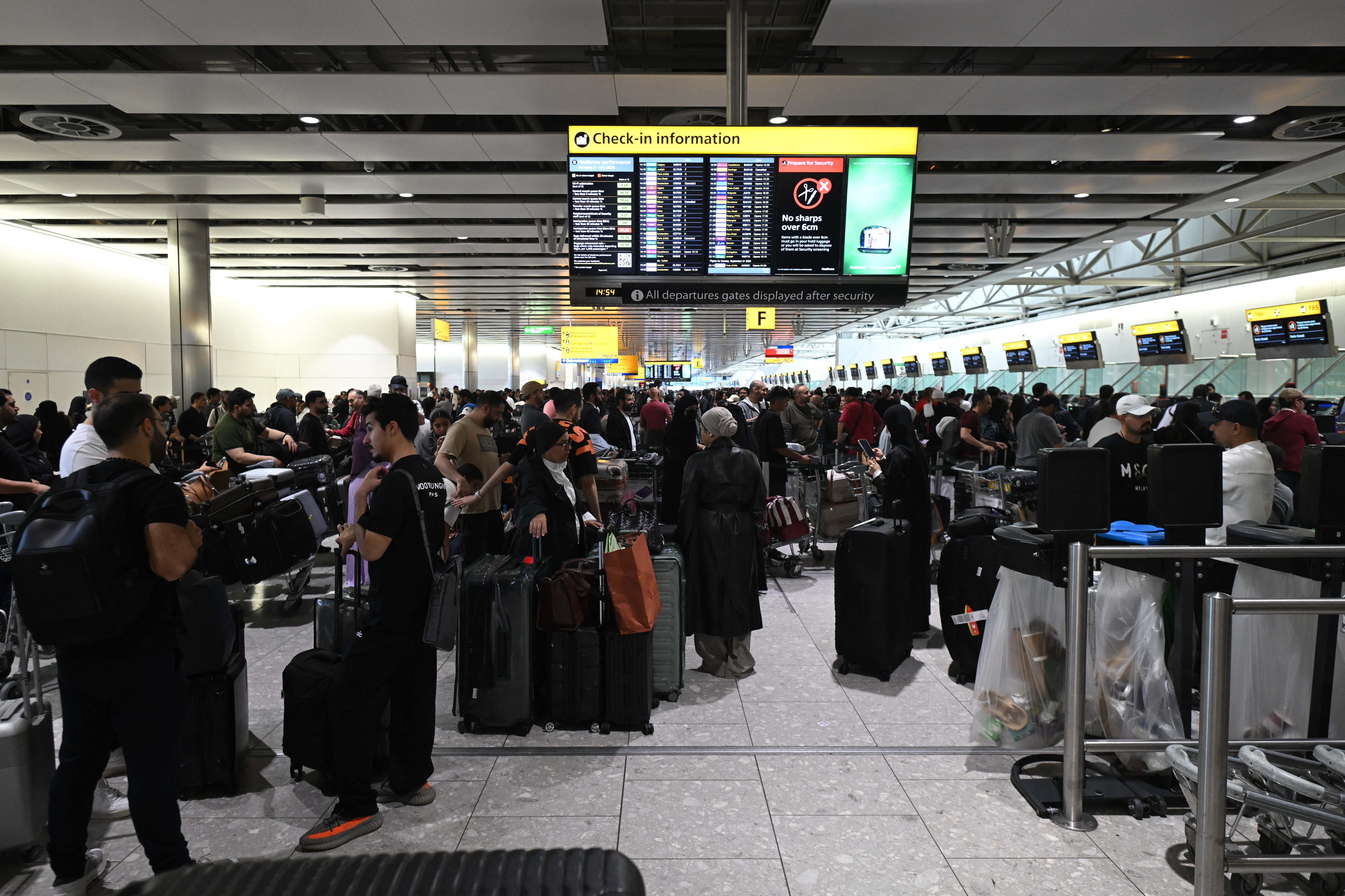 Travellers wait in terminal 4 at Heathrow Airport, west of London on September 20, 2025.