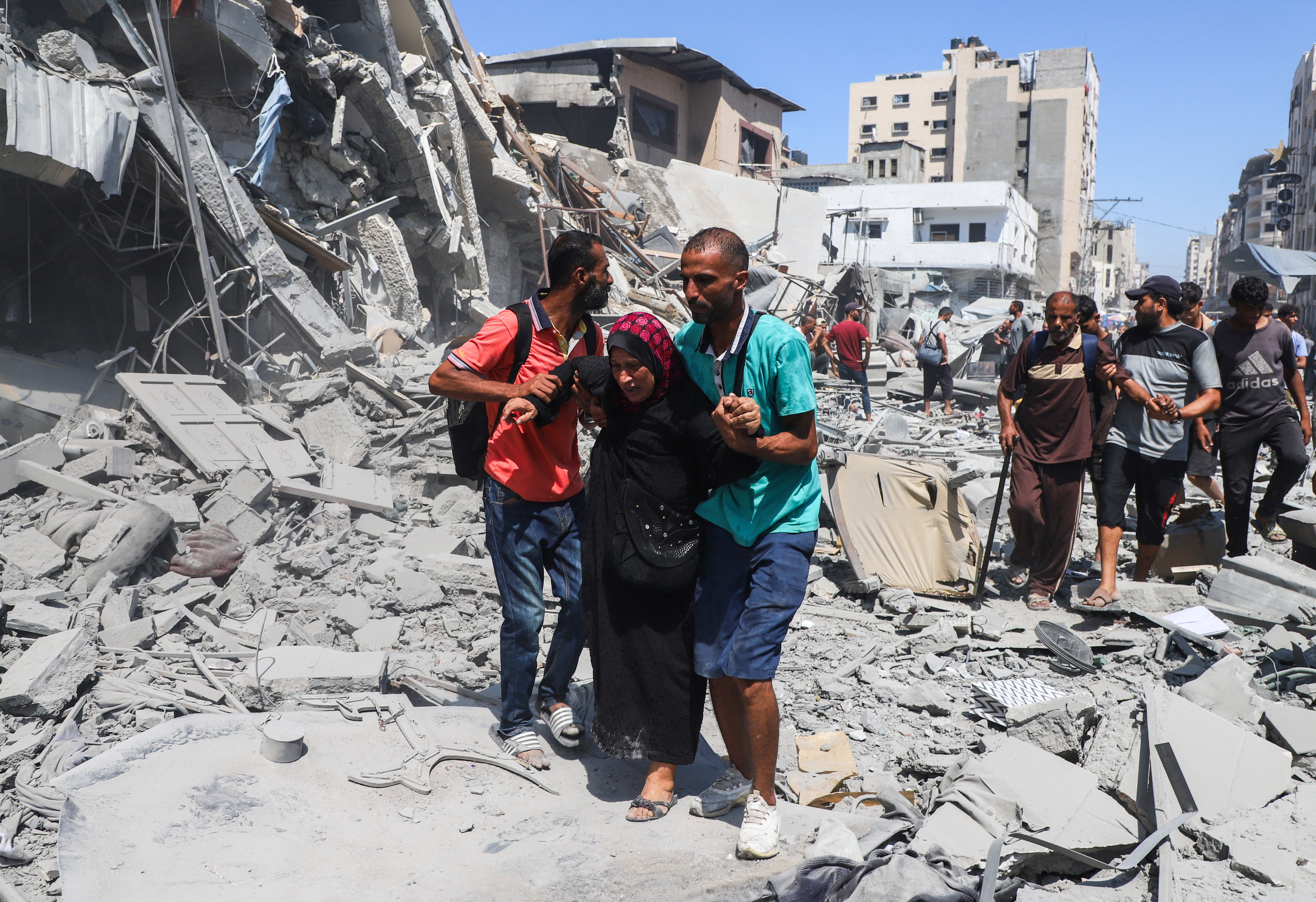 Palestinians inspect the site of an evacuated house, after it was hit by an Israeli air strike