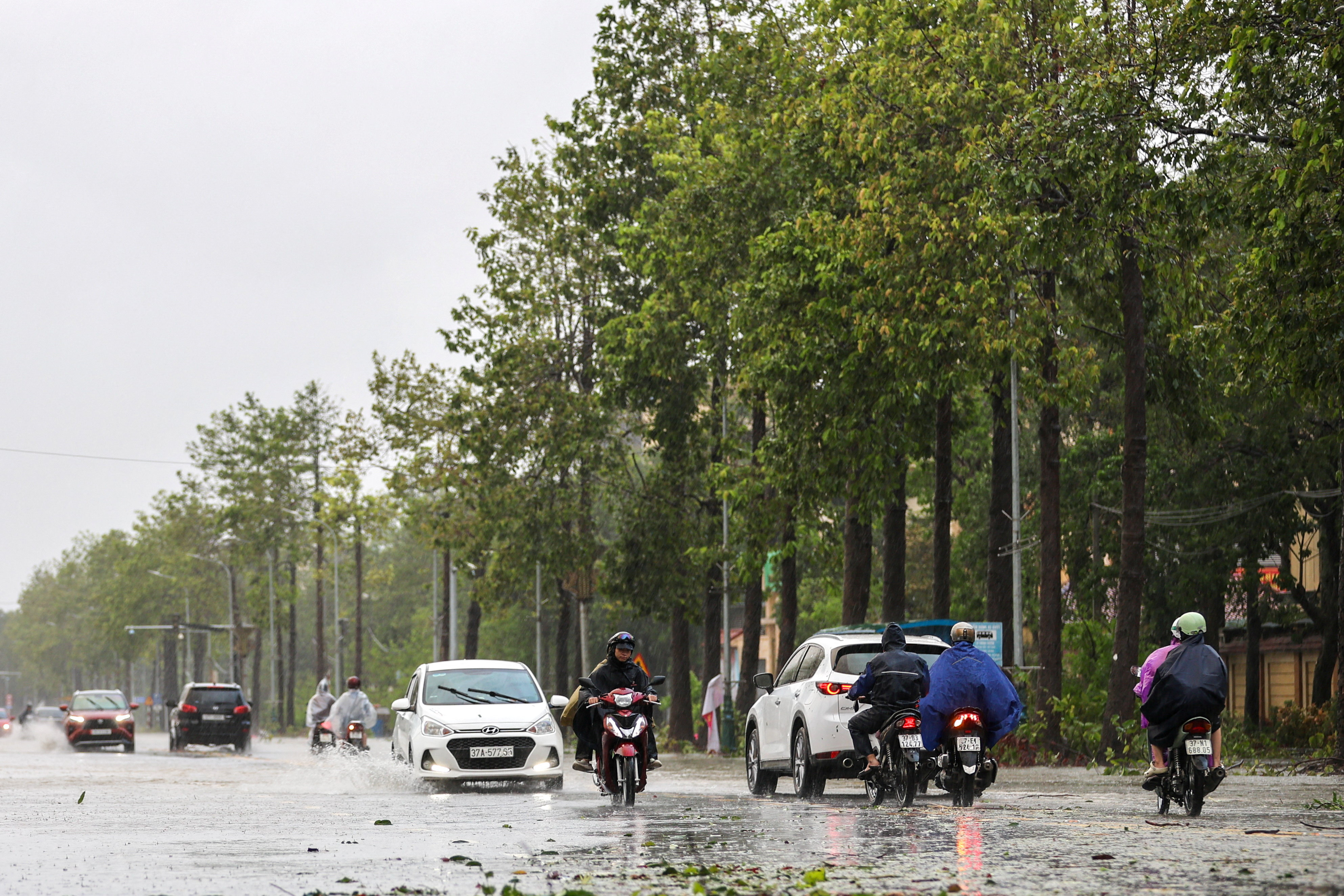 People commute on a flooded street after Typhoon Bualoi makes landfall in Nghe An province, Vietnam