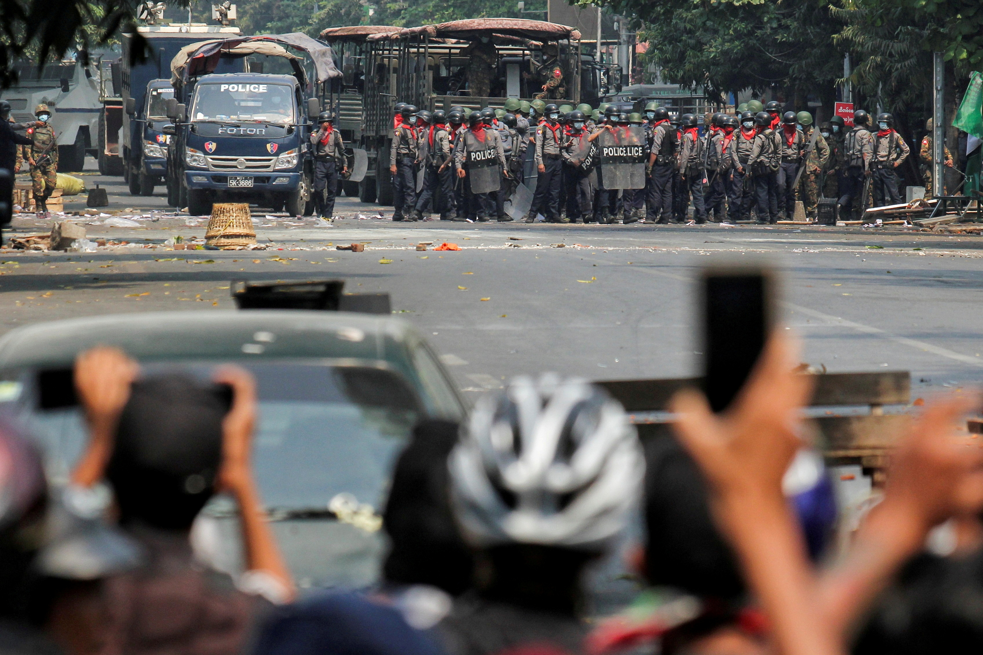 Police stand on a road during an anti-coup protest.