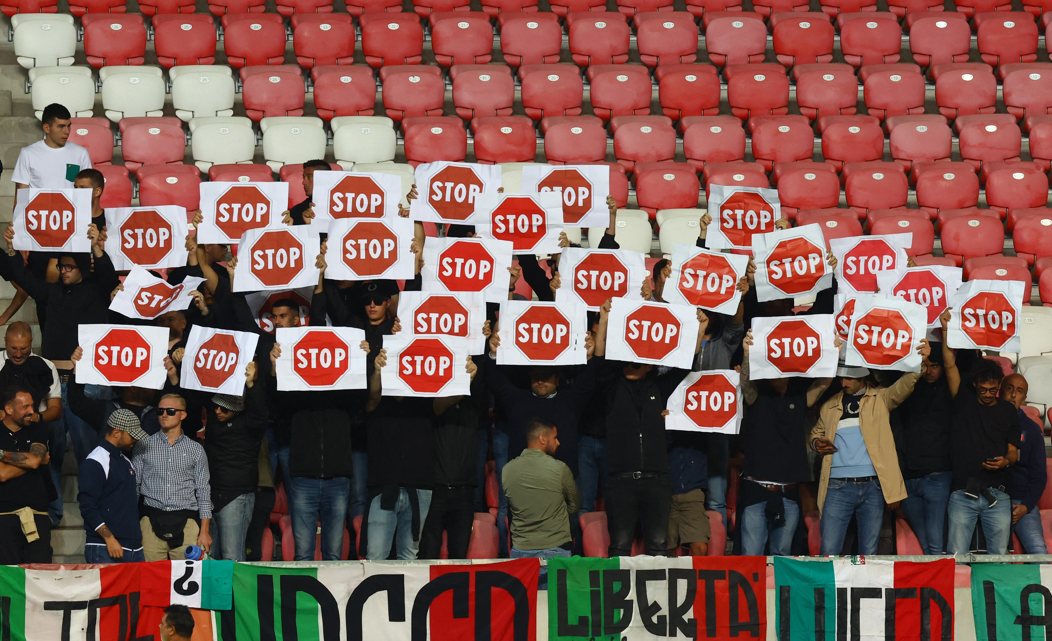 Italy fans hold banners in protest inside the stadium before the Israel match