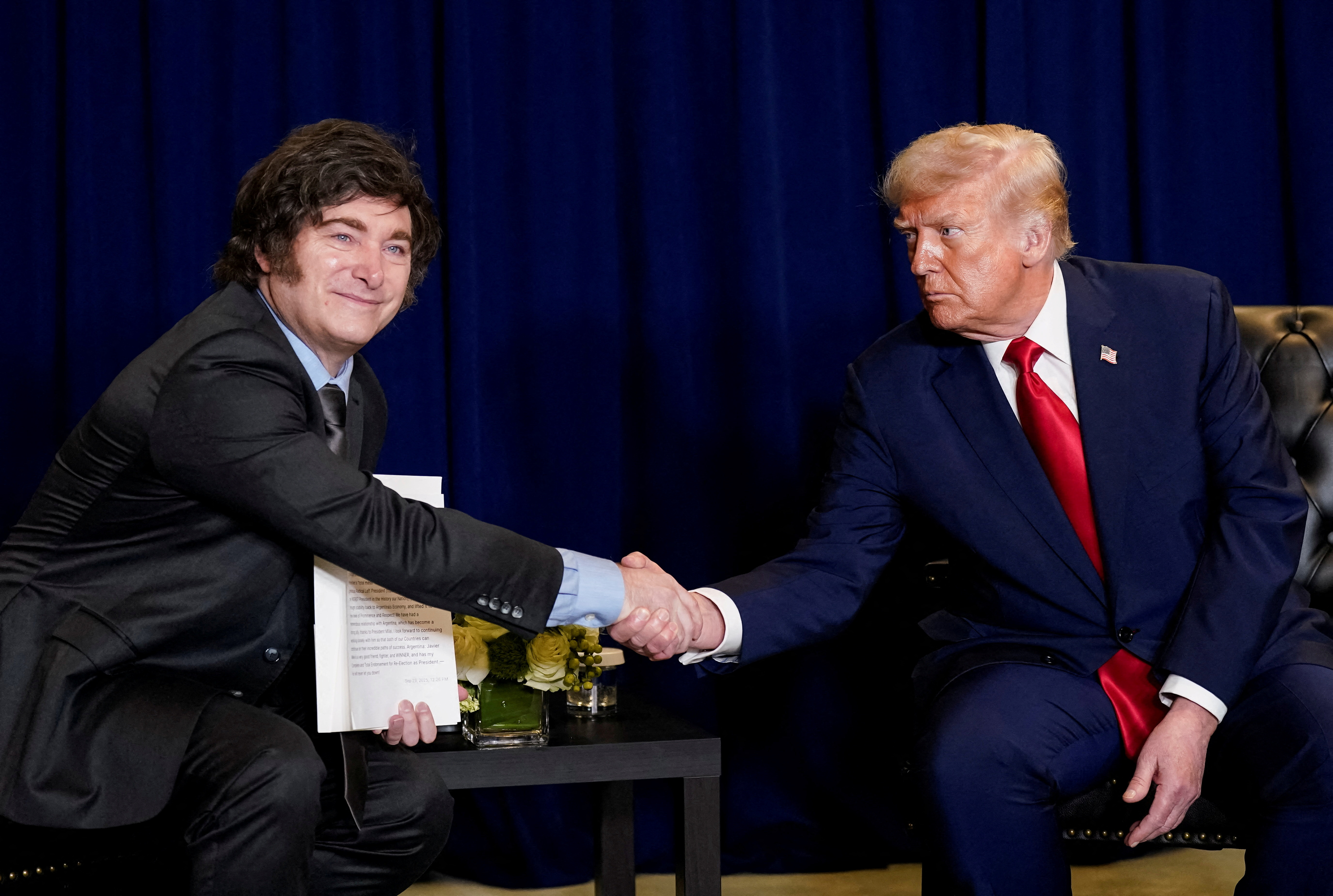 Donald Trump shakes hands with Javier Milei