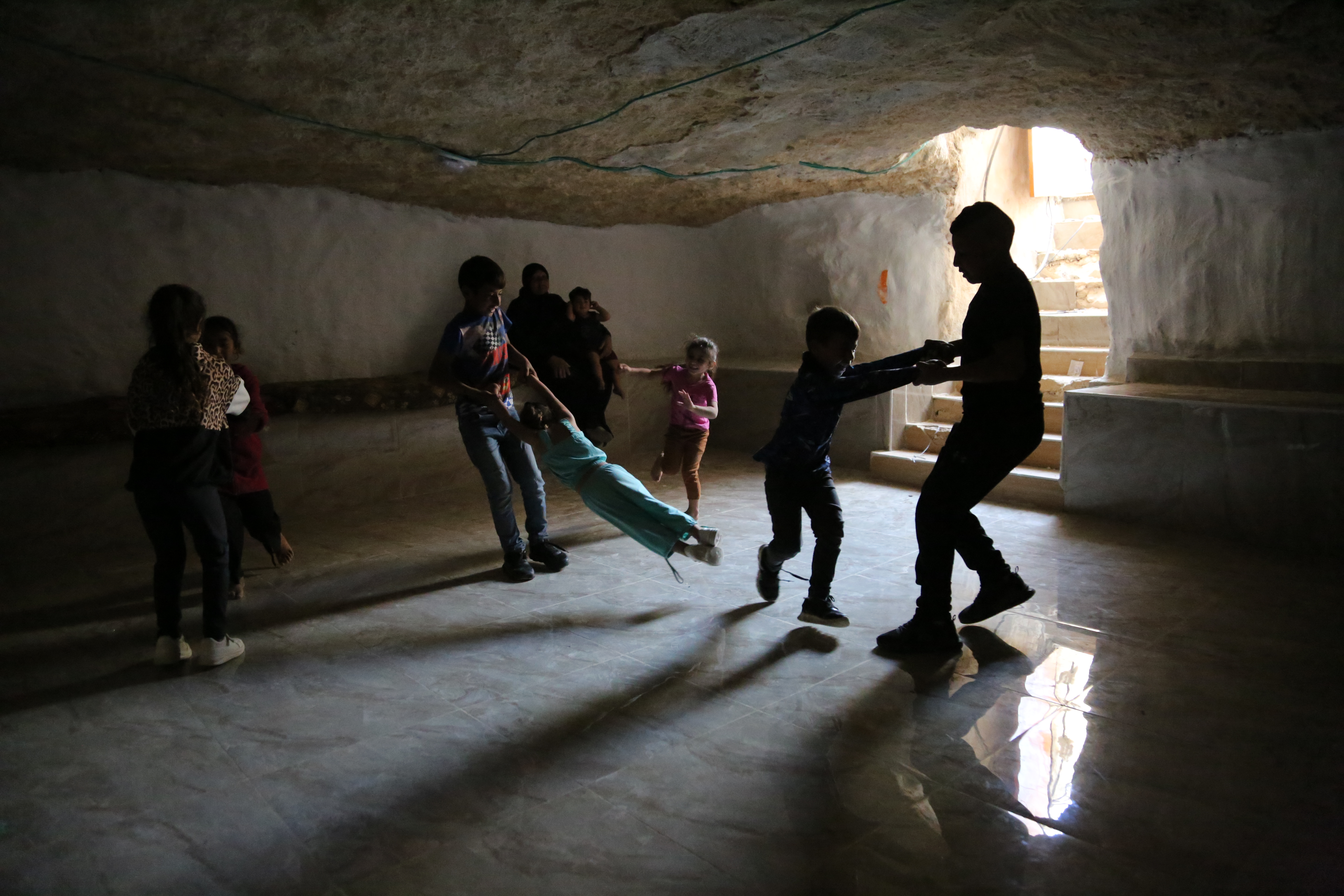 Children play in a cave that has been paved