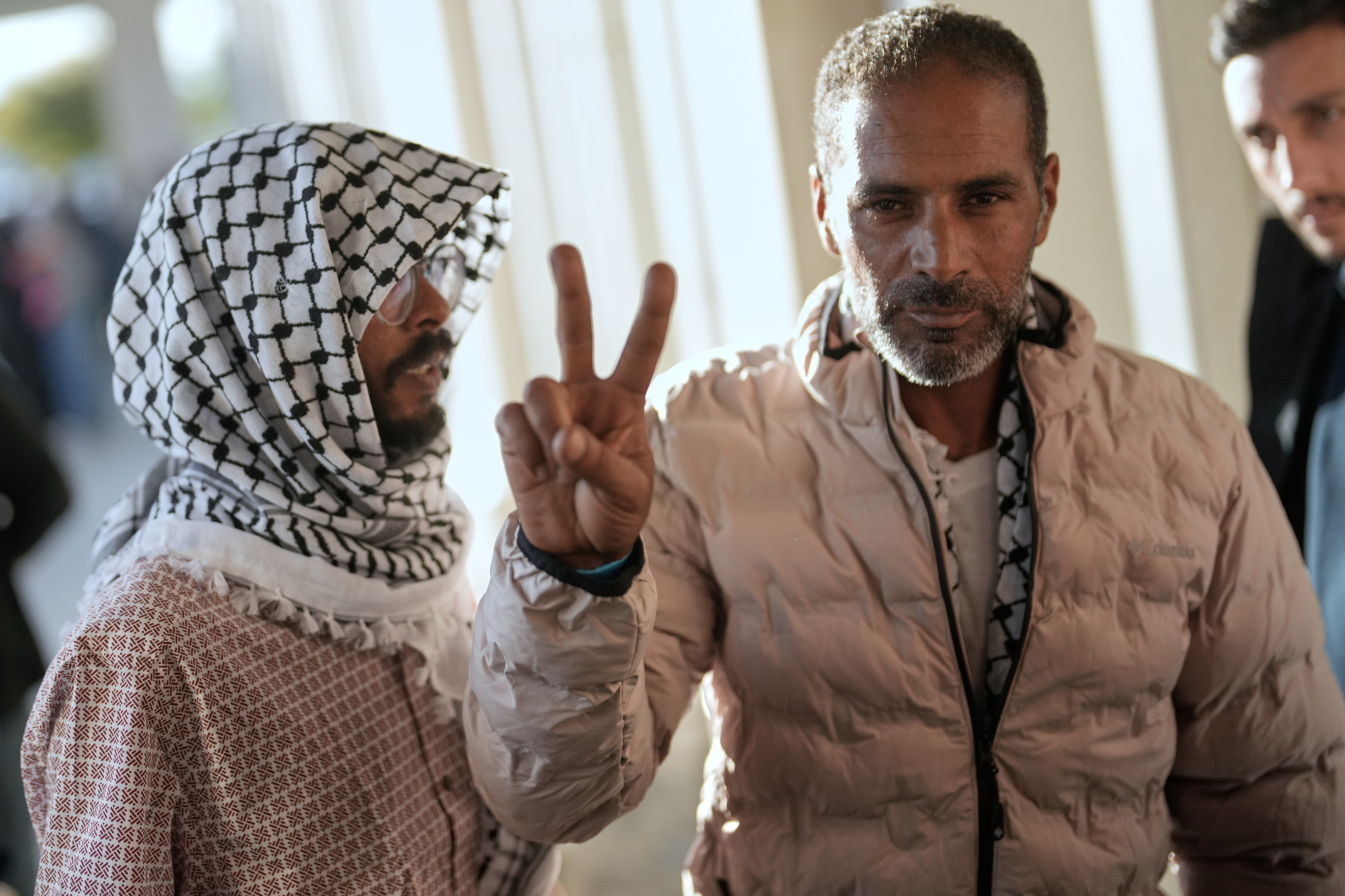 Activists from the Global Sumud Flotilla give the peace sign after arriving at Istanbul Airport in Istanbul, Turkey, Saturday