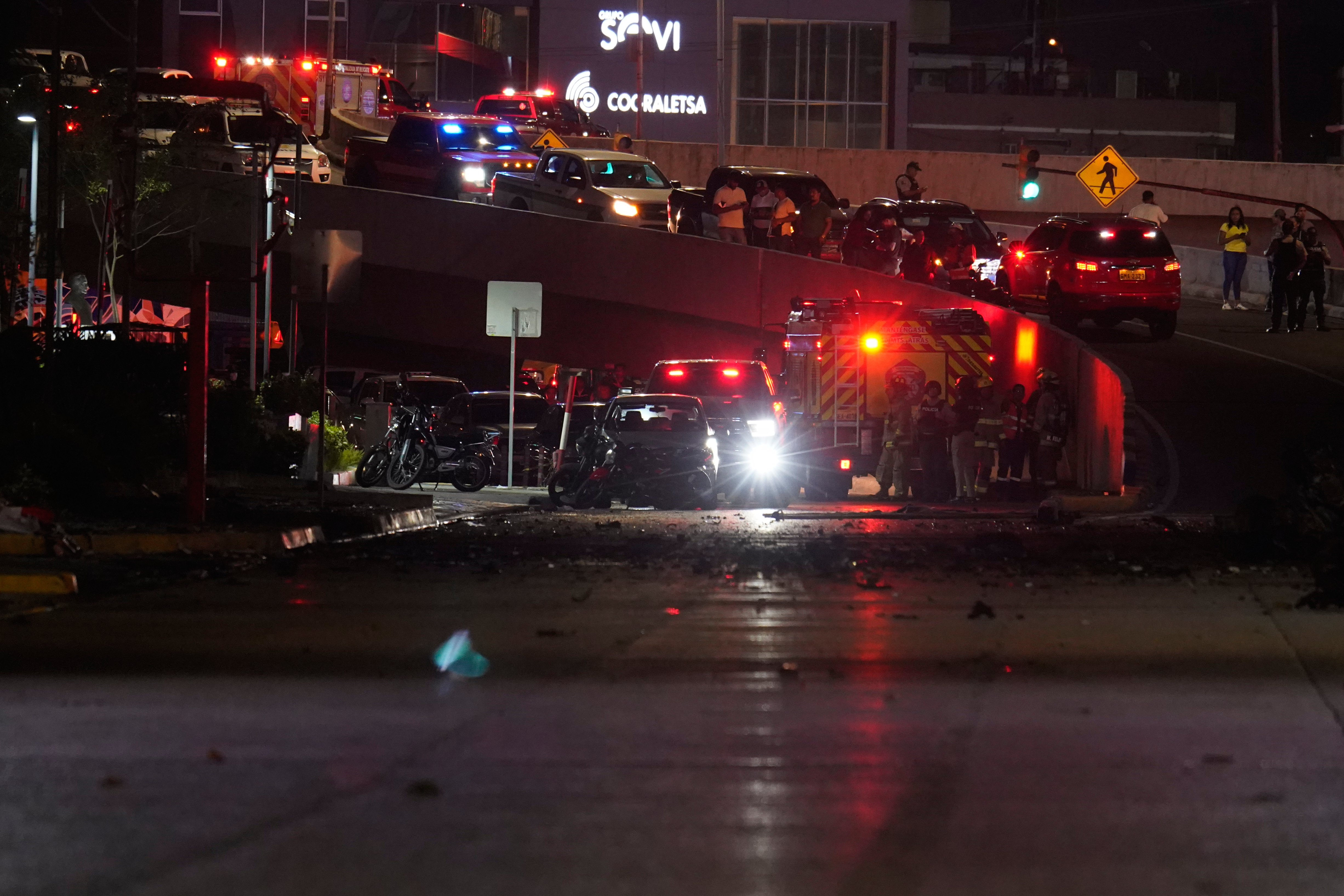 Police, firemen and security officials inspect the damage at the site of a car explosion on a shopping street in Guayaquil, Ecuador