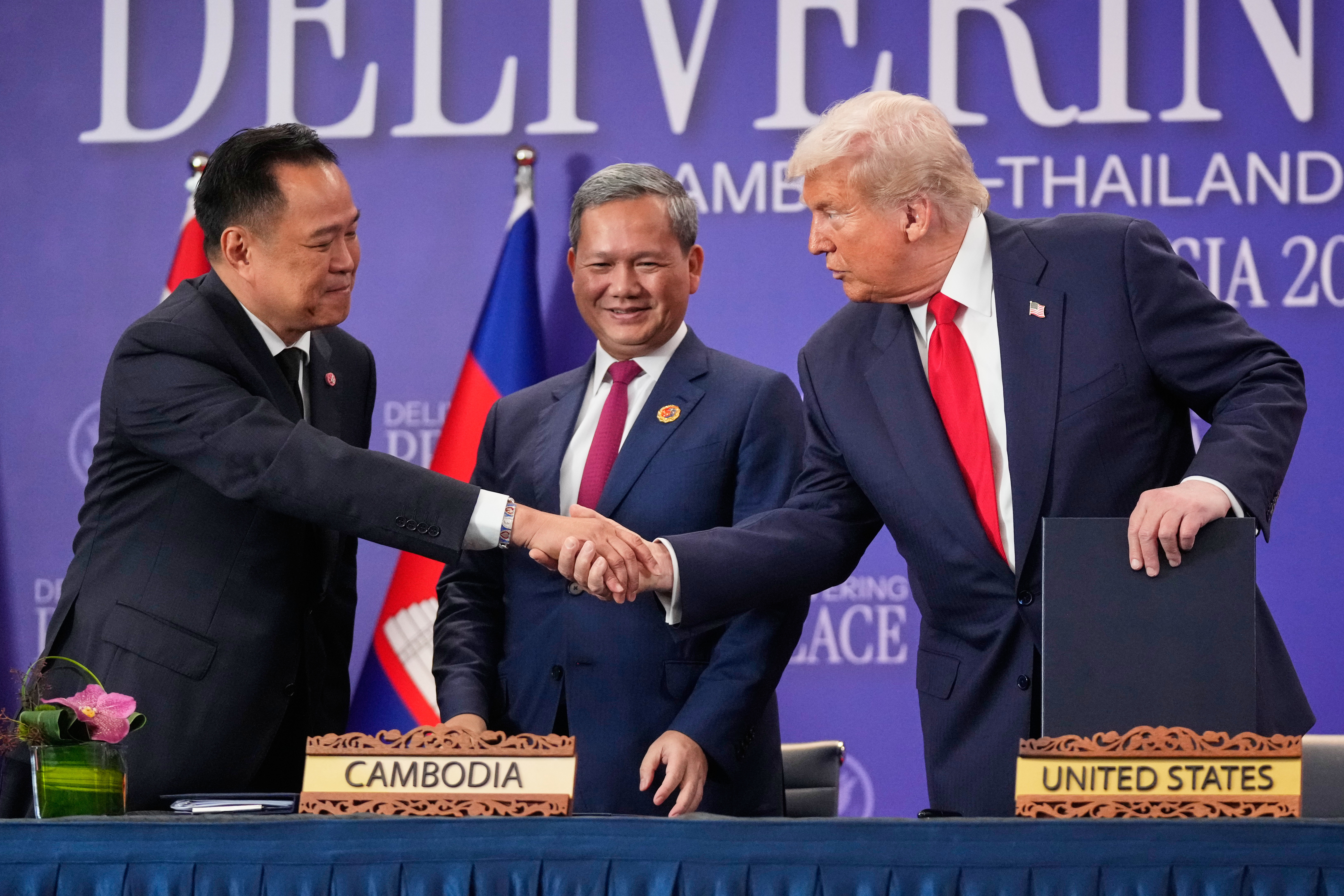 President Donald Trump shakes hands with Thailand's Prime Minister Anutin Charnvirakul, left, as Cambodian Prime Minister Hun Manet watches during a signing ceremony.