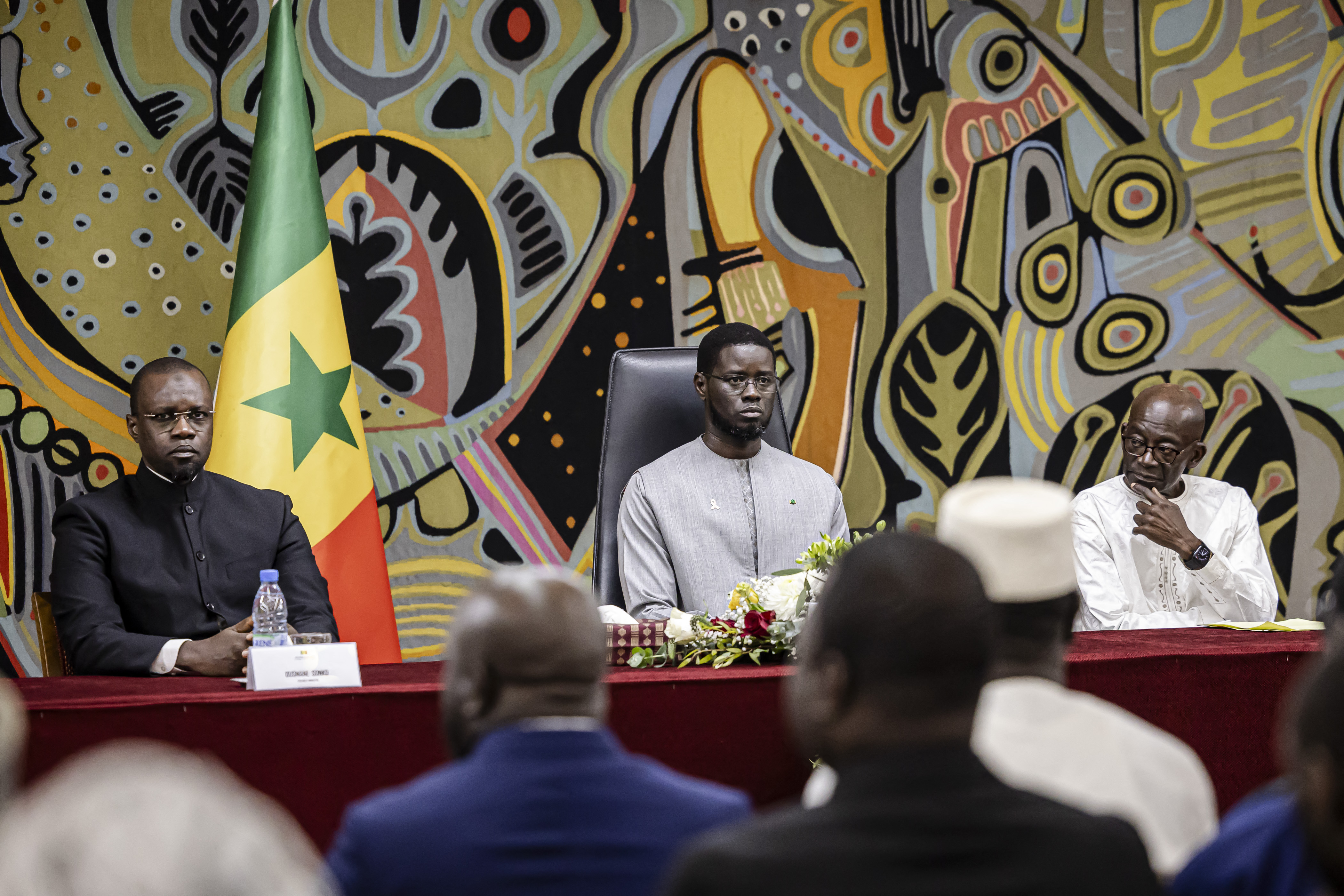 Senegal Prime Minister Ousmane Sonko (L), Senegal President Bassirou Diomaye Faye (C) and the President of the Committee for the Commemoration of the Thiaroye massacre Mamadou Diouf (R) attend a ceremony after receiving the official report on the Thiaroye massacre, at the Presidential Palace in Dakar, on October 16, 2025.