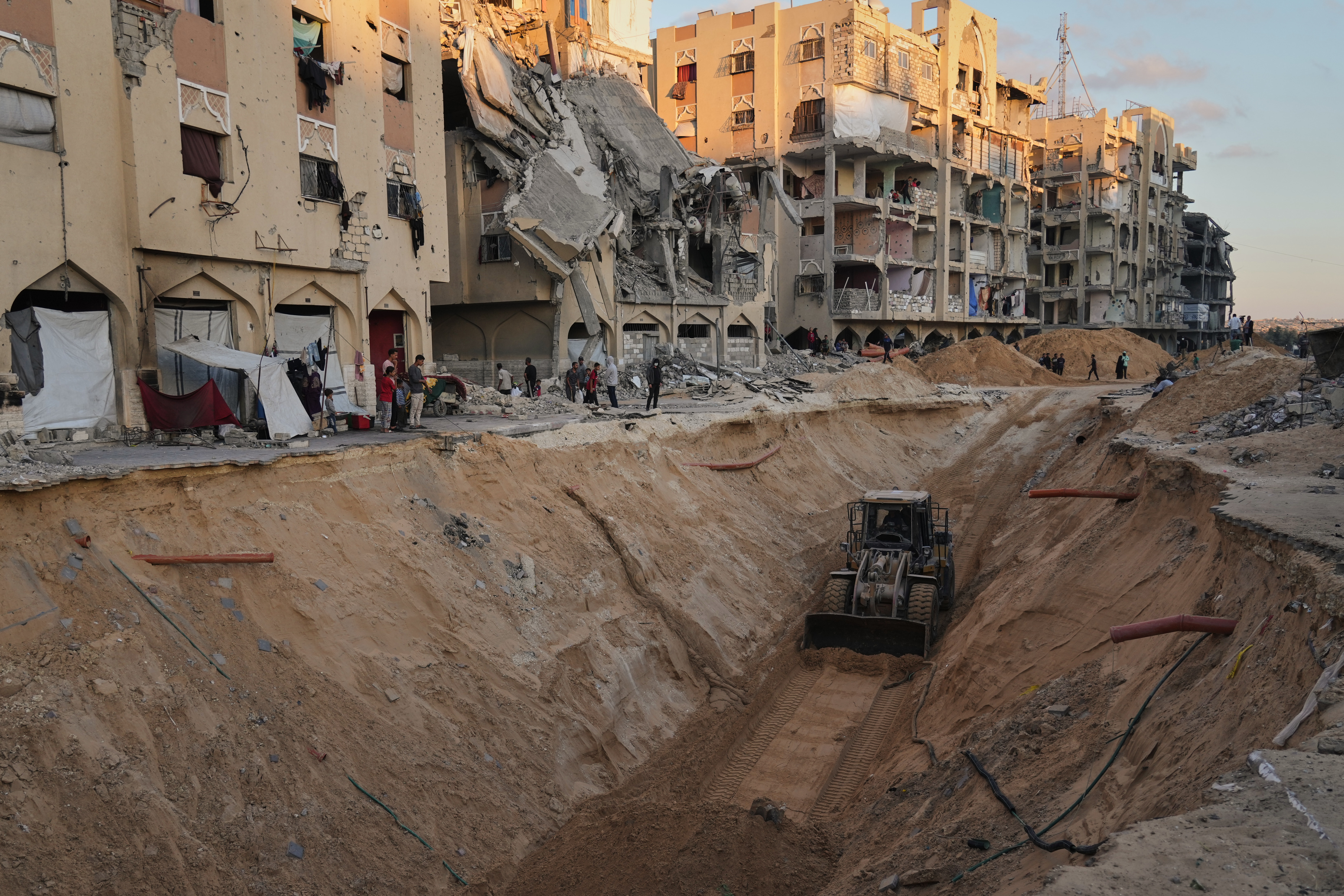 Members of the Hamas militant group searching for bodies of the hostages in Khan Younis, southern Gaza Strip, Saturday, Oct. 18, 2025. (AP Photo/Jehad Alshrafi)