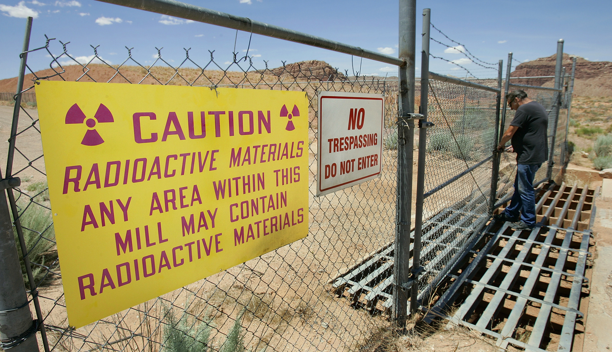 FILE - U.S. Energy Corp. resident project manager Daryl Winters locks the gate, on July 12, 2006, at the Shootaring Mill north of Ticaboo, Utah. (AP Photo/Douglas C. Pizac)