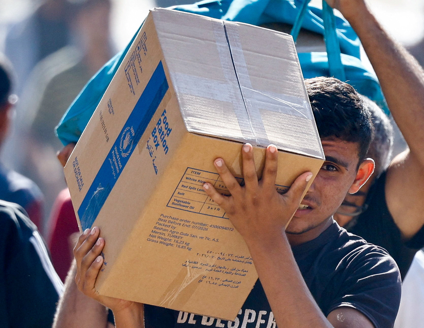 A Palestinian carries aid supplies that entered Gaza, amid a ceasefire between Israel and Hamas in Gaza, in Zawaida in the central Gaza Strip, Oct. 21, 2025. [Mahmoud Issa/Reuters]