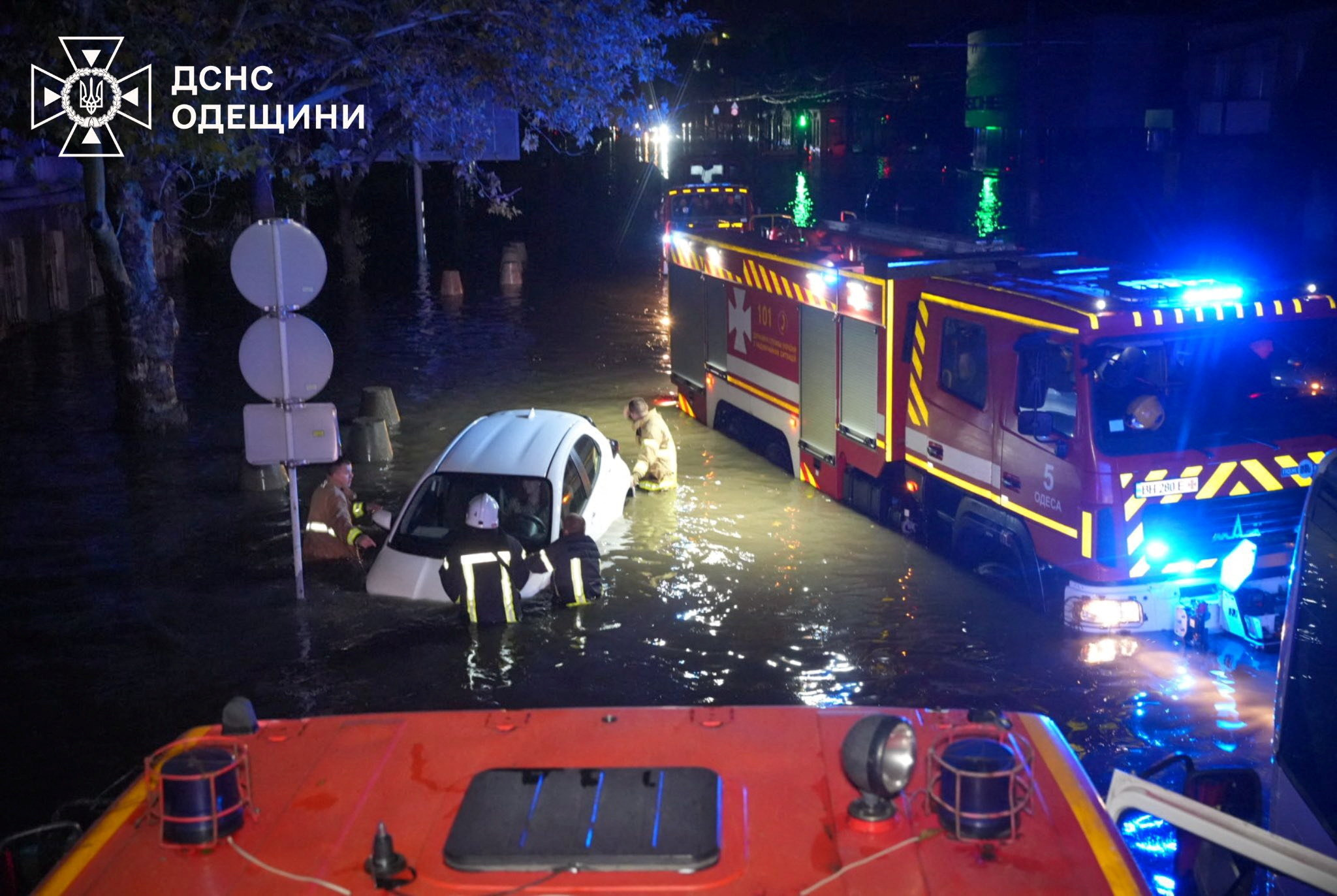 Rescuers push a partially submerged car on a flooded street, following unprecedented rainfall in Odesa, Ukraine in this handout picture released October 1, 2025. Press service of the State Emergency Service of Ukraine in Odesa region/Handout via REUTERS ATTENTION EDITORS - THIS IMAGE HAS BEEN SUPPLIED BY A THIRD PARTY. MUST NOT OBSCURE LOGO.