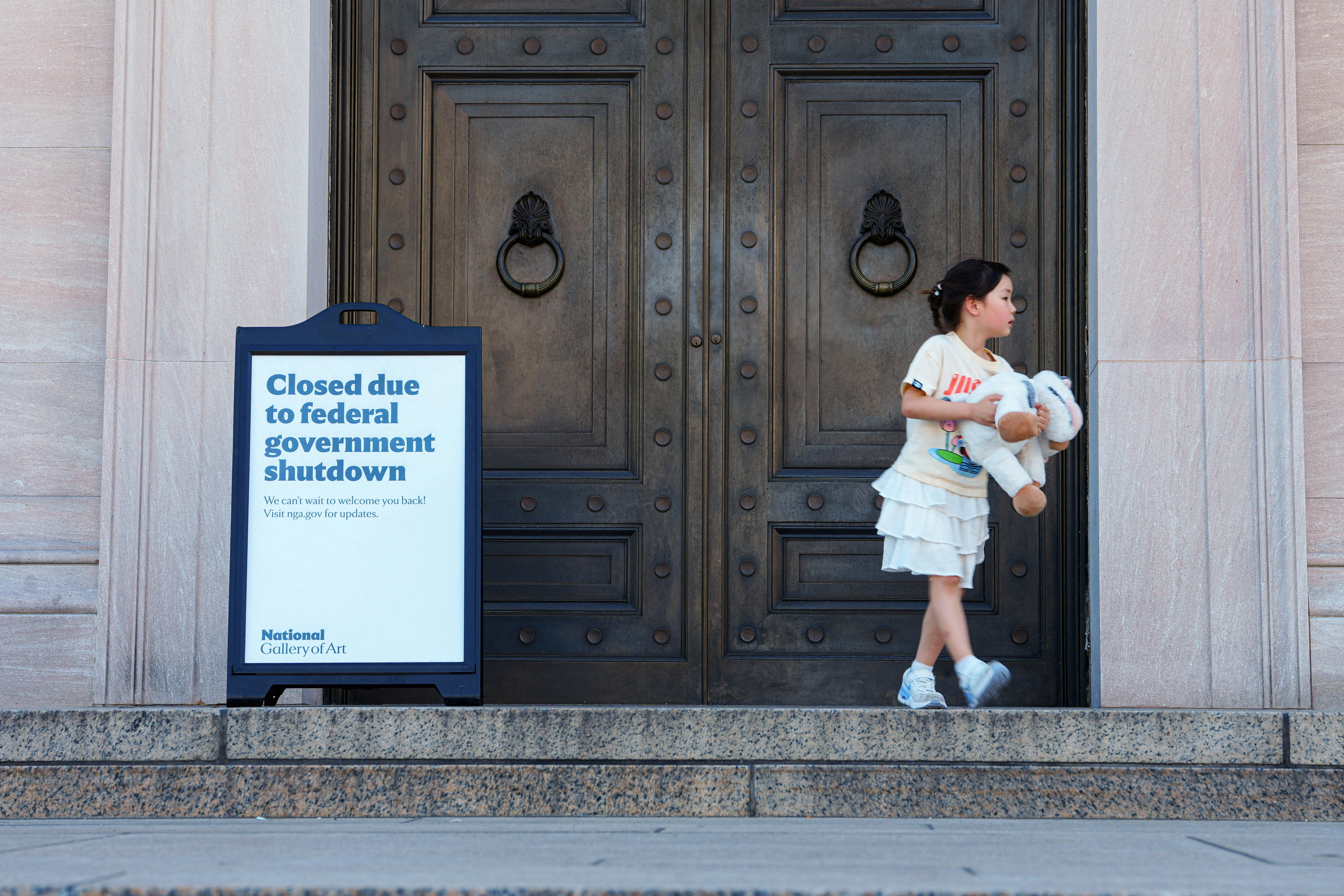 A child walks past the closed National Gallery of Art during the fifth day of a partial government shutdown in Washington, D.C., U.S., October 5, 2025. REUTERS/Aaron Schwartz TPX IMAGES OF THE DAY