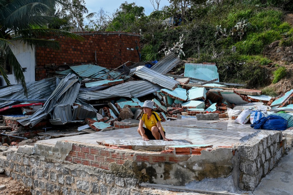 A resident looks on next to the debris of a structure destroyed in high winds in Nhon Hai fishing village near Quy Nhon in the aftermath of Typhoon Kalmaegi in Gia Lai province, central Vietnam on November 7, 2025. [File: NHAC NGUYEN/AFP]