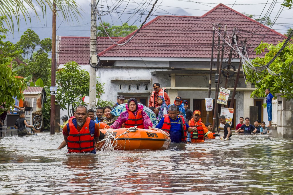 A rescue team evacuates women and children in a rubber boat as floodwaters hit a residential area in Padang, West Sumatra on November 25, 2025. [File: Ade Yuandha/AFP]