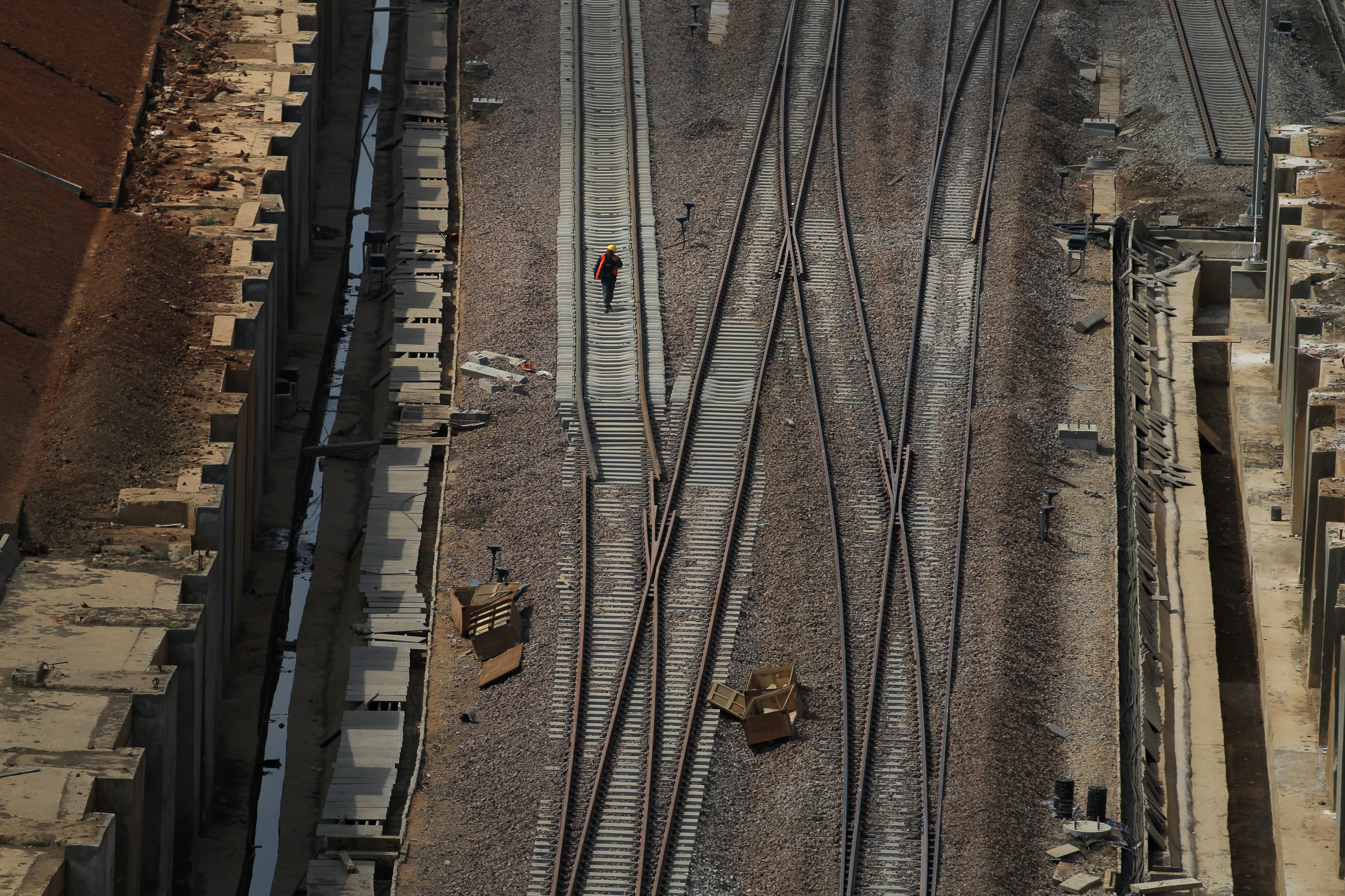 A labourer walks at a construction site for the new Kunming railway station in Chenggong, Yunnan
