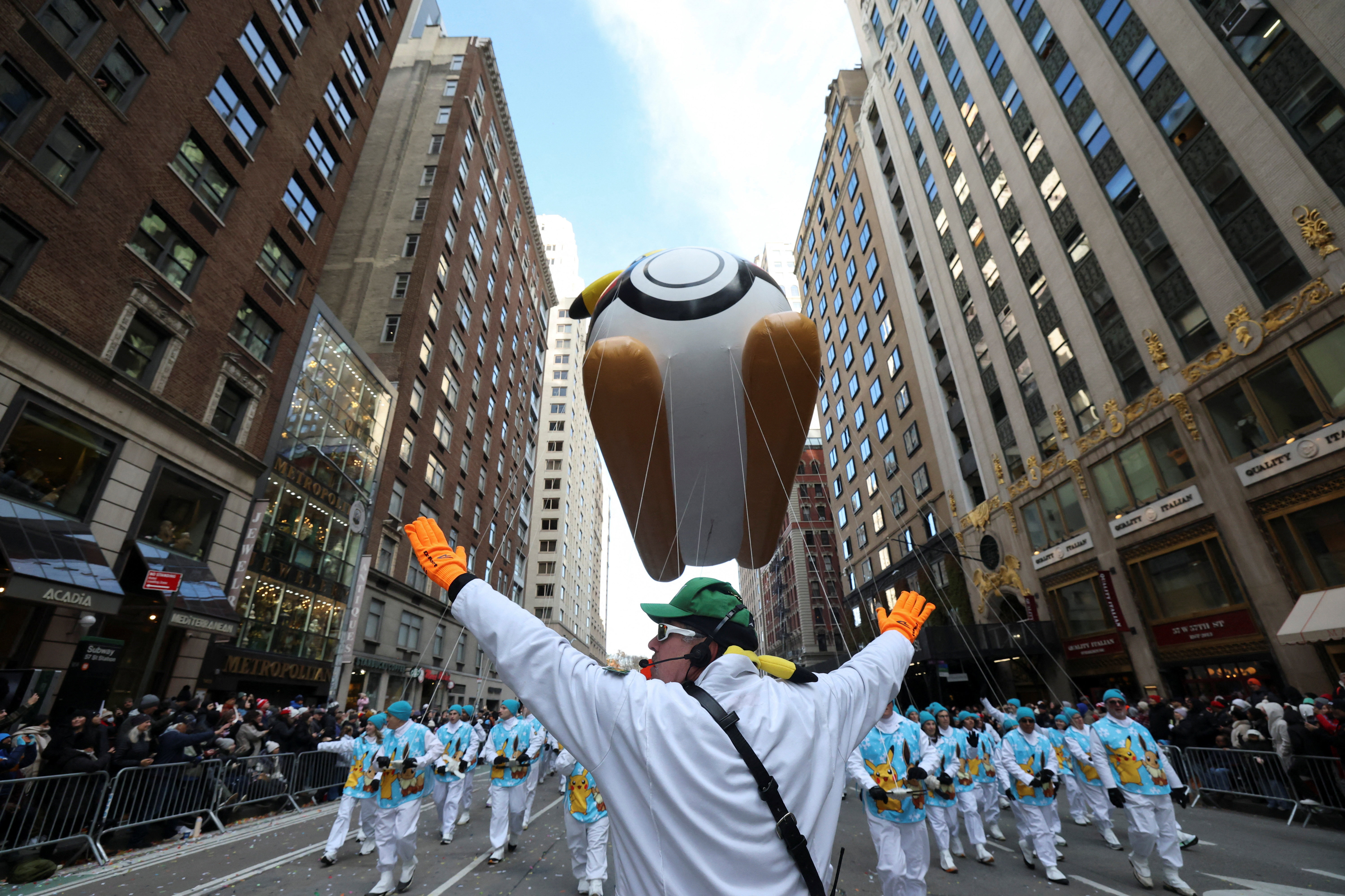 Parade participants help guide a Pikachu balloon at the Macy's Thanksgiving Day parade