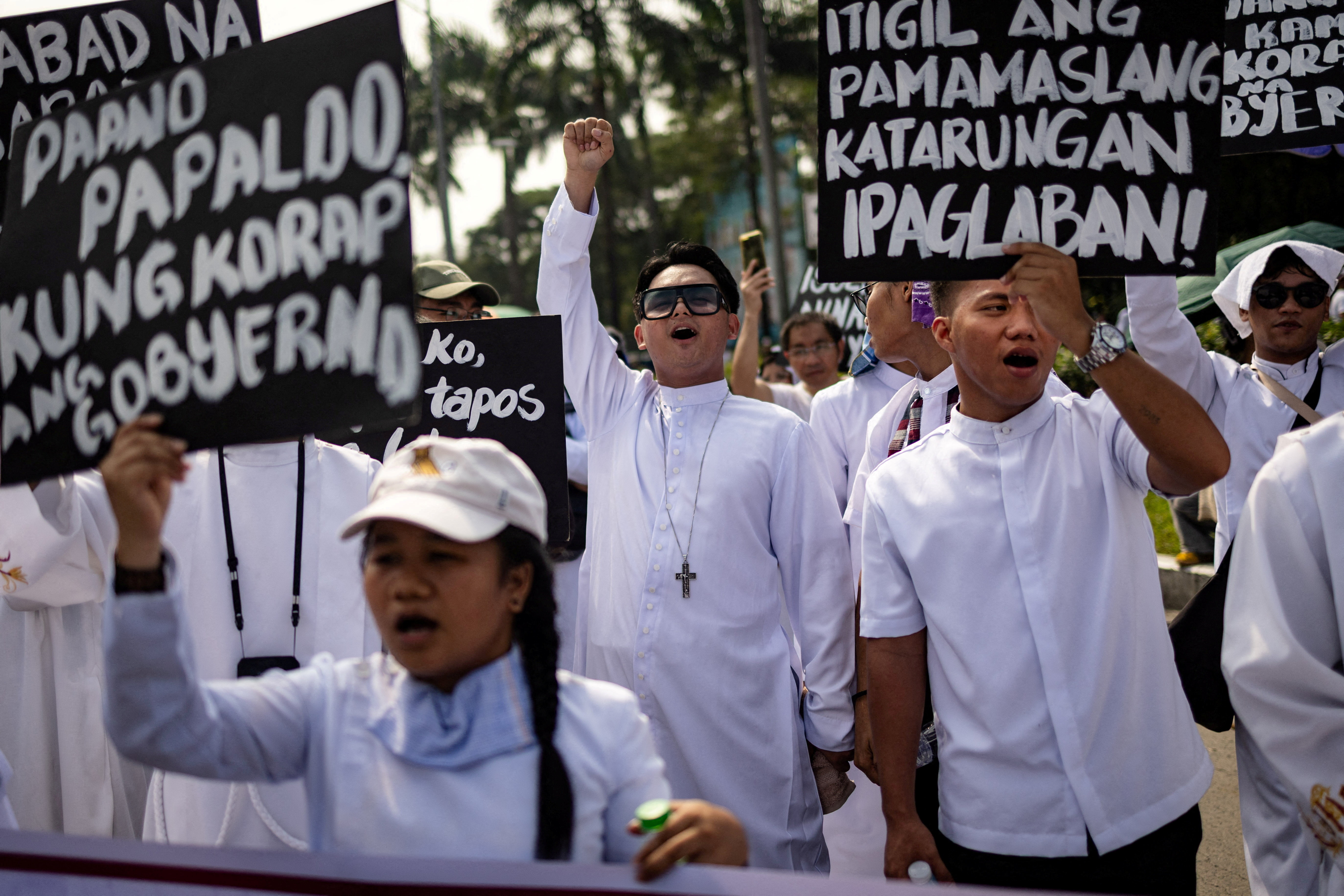 Filipino members of the clergy shout and raise placards during an anti-corruption protest over widespread corruption allegations linked to government infrastructure projects