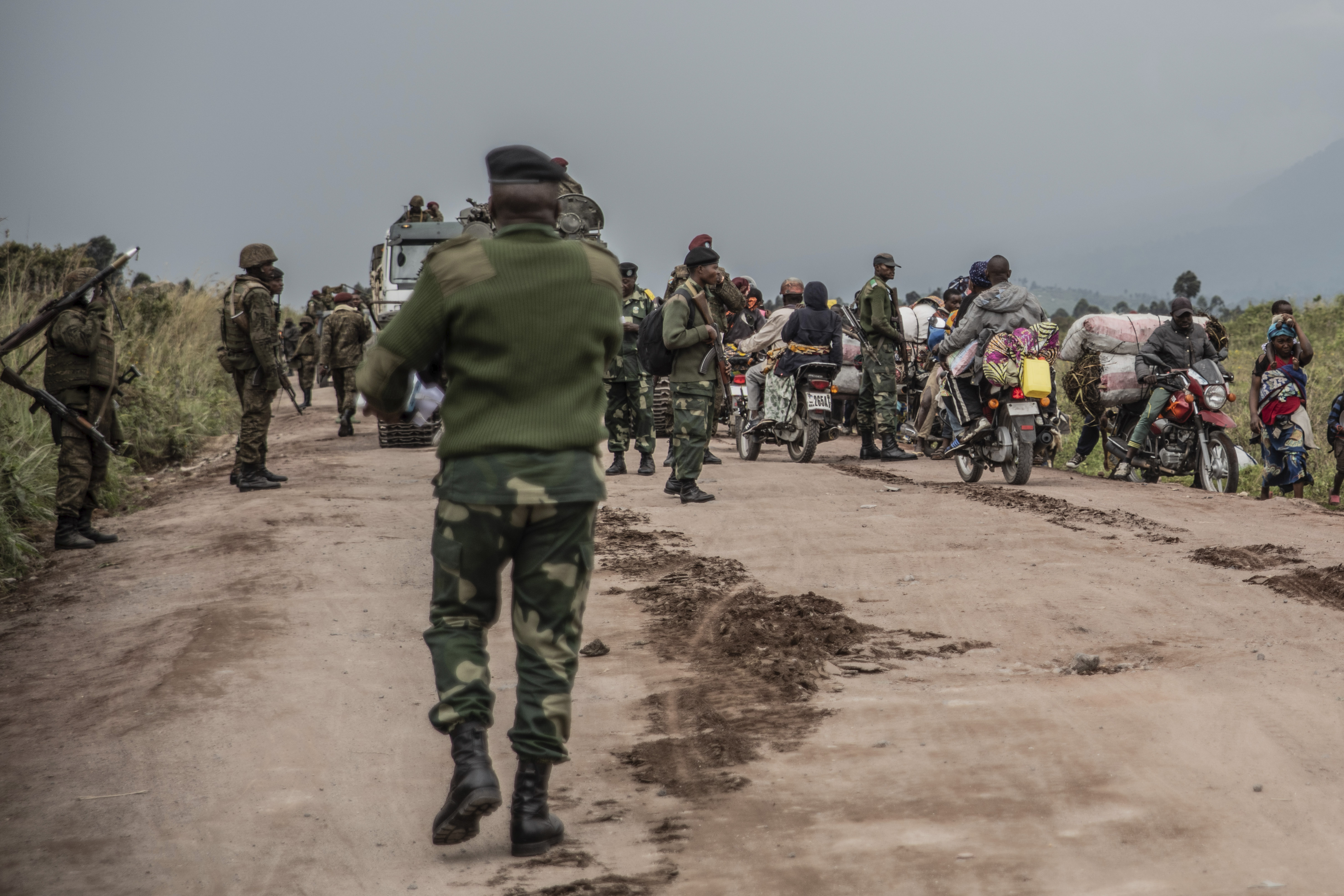 People walk on the road near Kibumba, north of Goma, DR Congo, as they flee fighting between Congolese forces and M23 rebels in North Kivu on May 24, 2022.