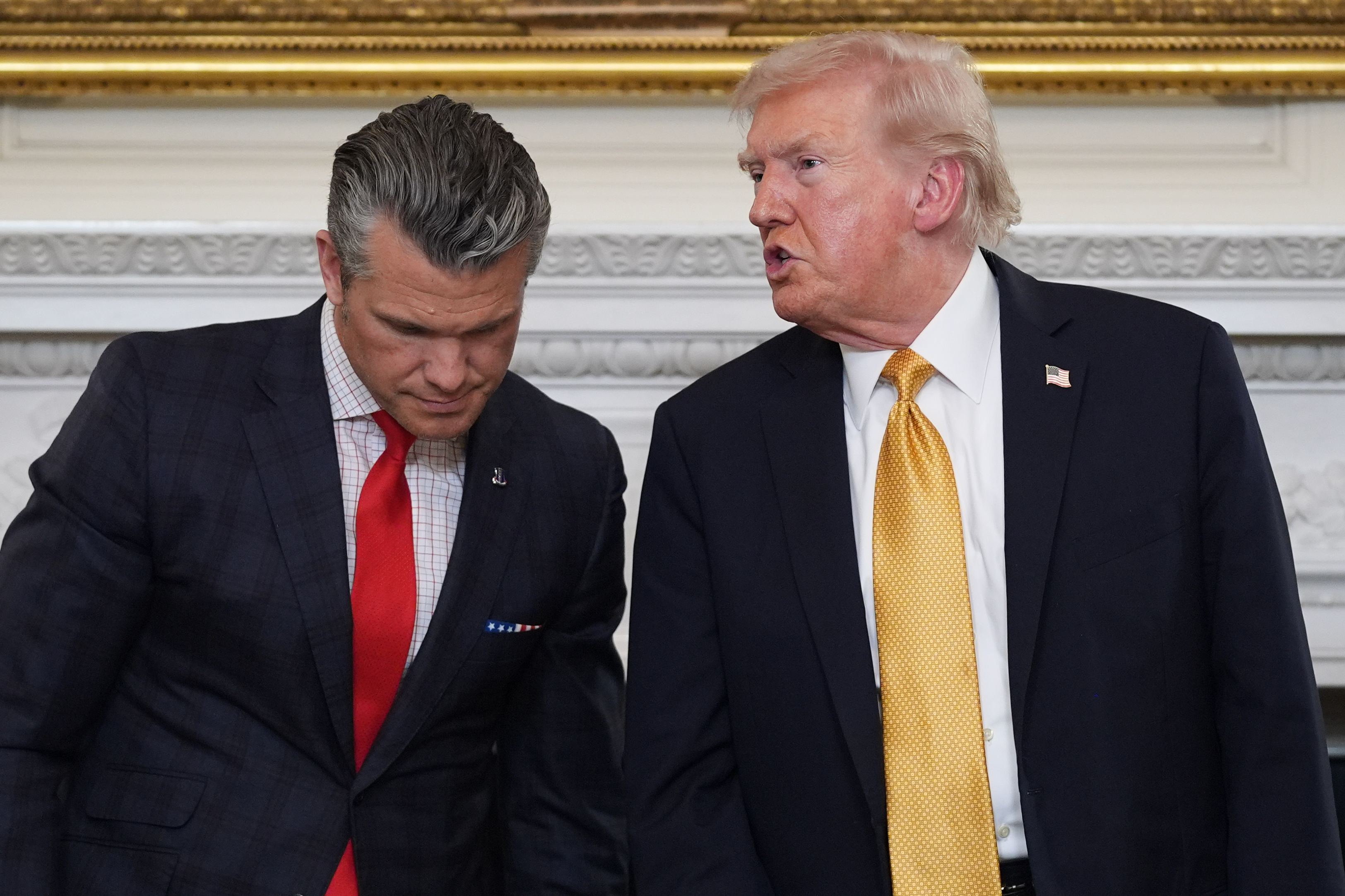 President Donald Trump talks with Defense Secretary Pete Hegseth