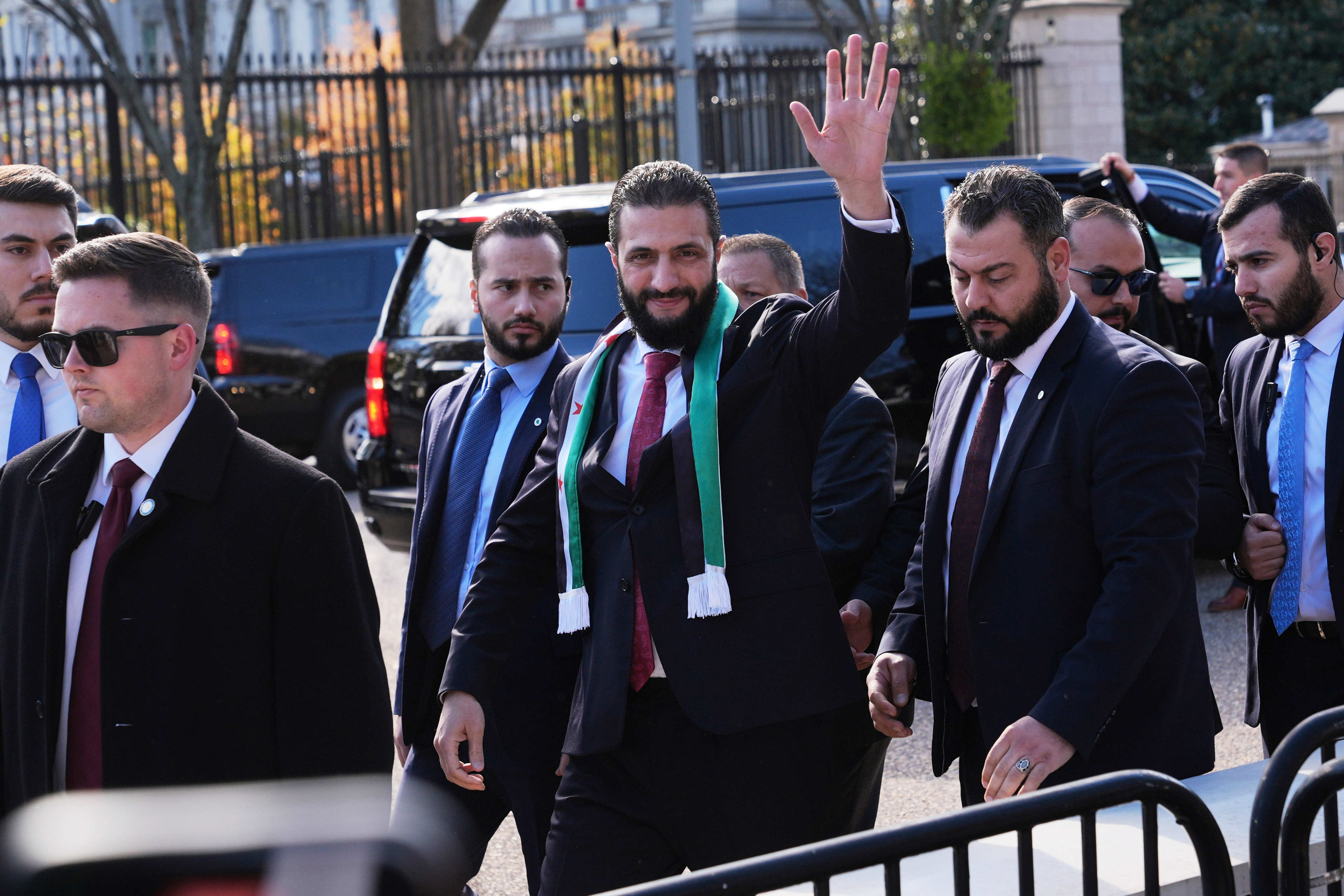 Syria&#039;s President Ahmed al-Sharaa waves as he greets supporters outside of the White House, Monday, Nov. 10, 2025, in Washington, following a meeting with President Donald Trump. [Jacquelyn Martin/AP Photo]