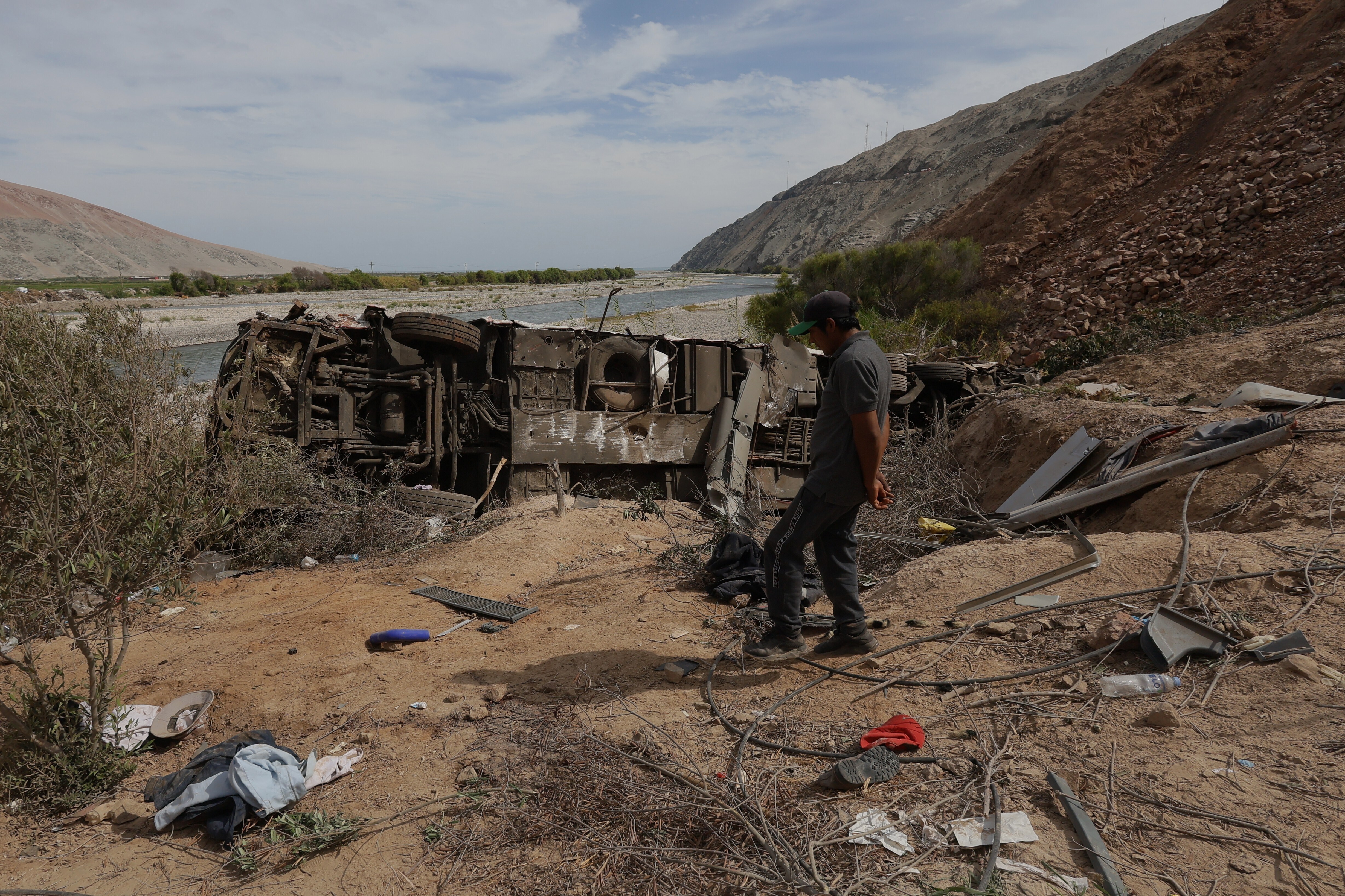 A man walks by a passenger bus after a deadly crash with a pickup truck in Peru&#039;s Arequipa region on November 12, 2025 [Kiara Tapia/AP]
