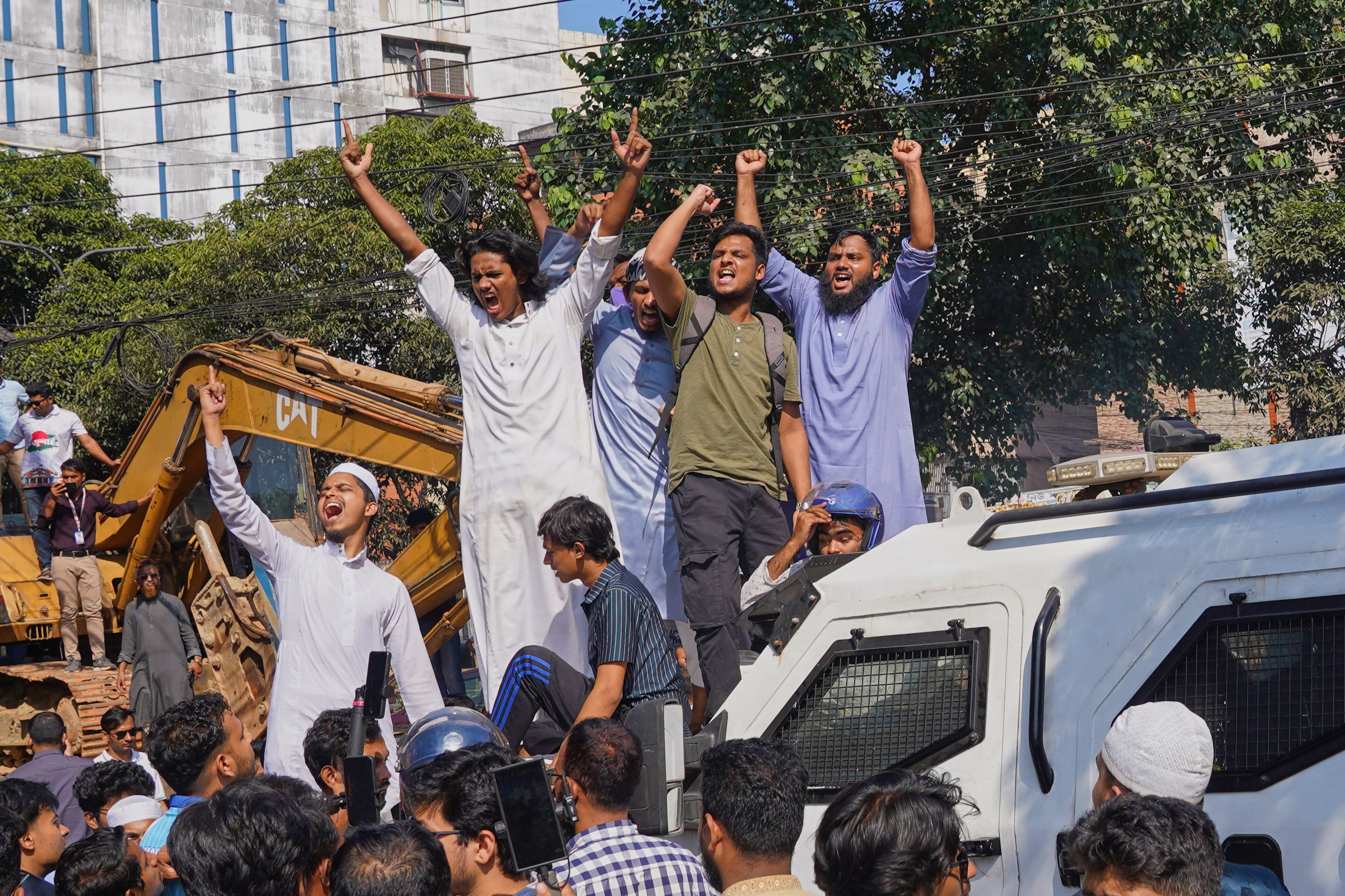Protesters shout slogans outside the demolished residence of Sheikh Mujibur Rahman, Bangladesh&#039;s former leader and the father of the country&#039;s ousted Prime Minister Sheikh Hasina ahead of an expected verdict against Hasina, in Dhaka, Bangladesh, Monday, Nov. 17, 2025. [Ahadul Karim Khan/AP Photo] (AP Photo)