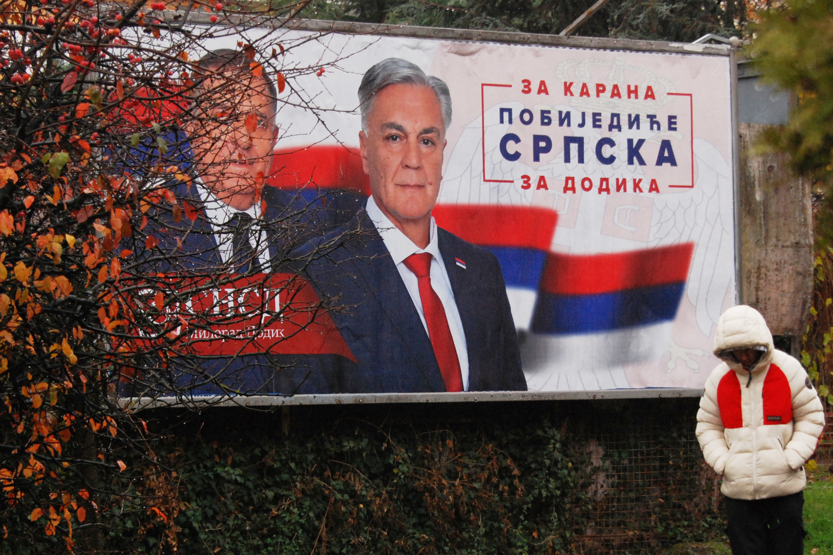 A man walks past an election billboard showing Bosnian Serb leader Milorad Dodik, and his SNSD party&#039;s candidate Sinisa Karan, for Republika Srpska&#039;s presidential election, in the town of Banja Luka, Friday, November 21, 2025 [Radivoje Pavicic/AP Photo]